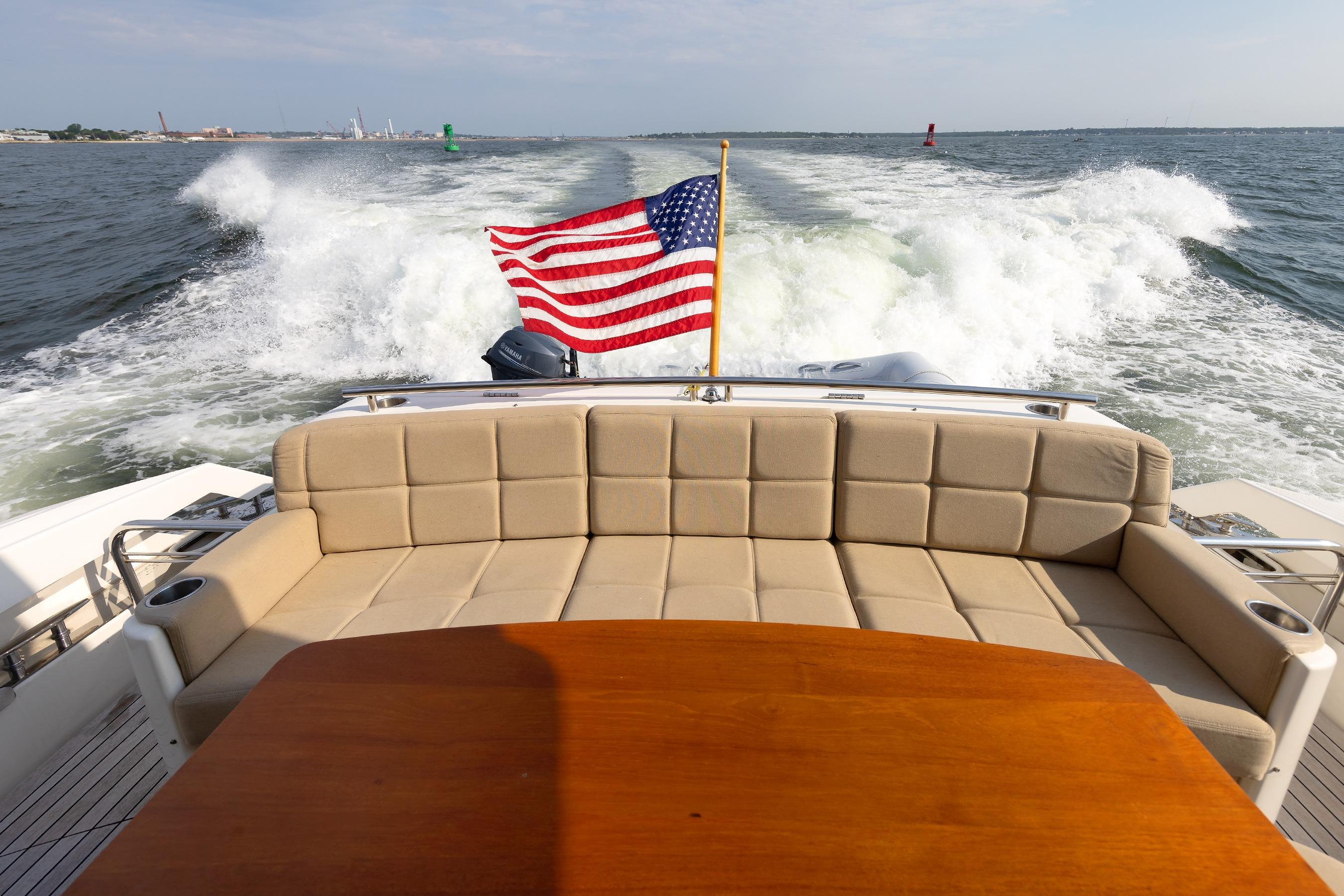 2014 Tiara 5000 Coupe yacht with American flag, cruising on open water.