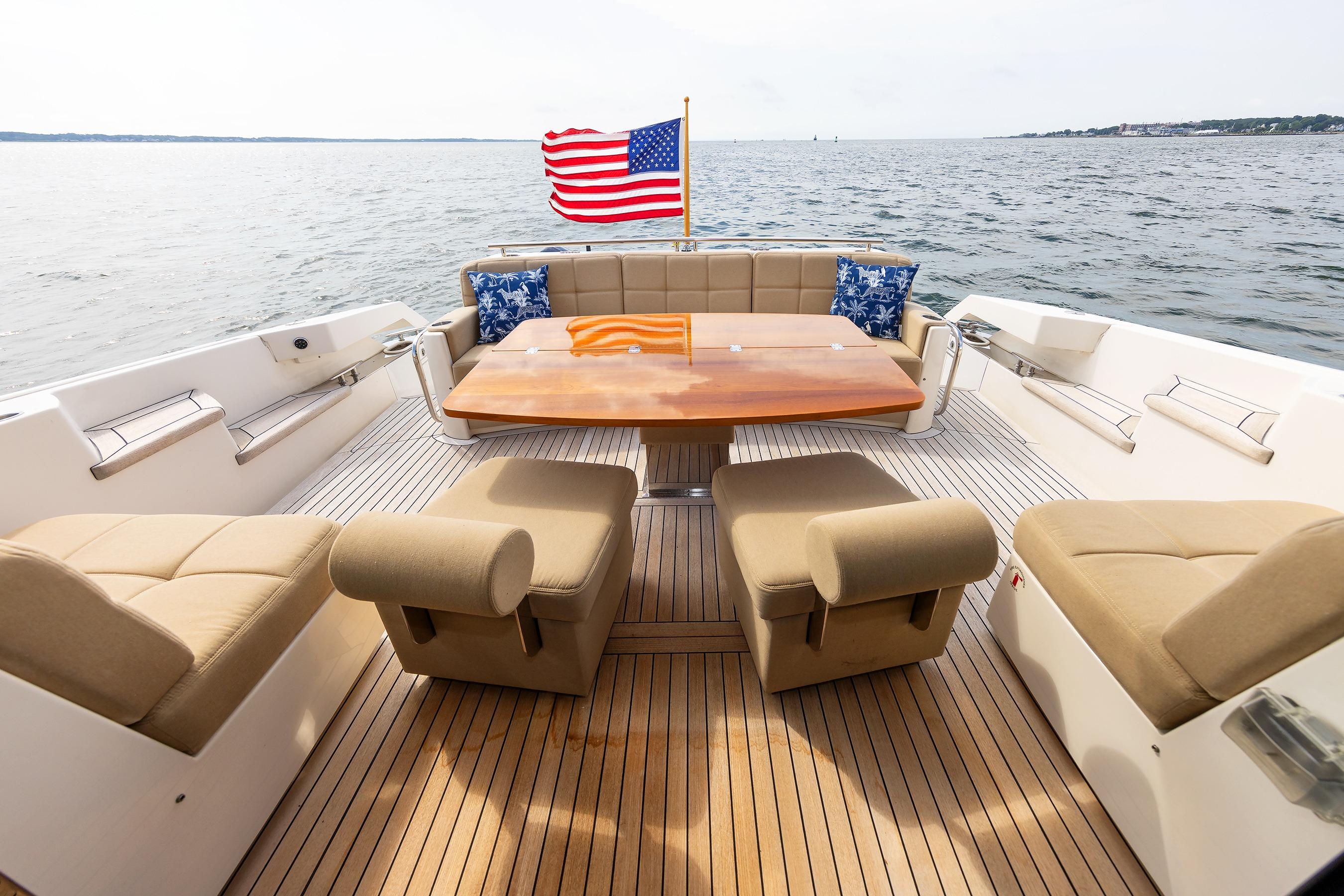 Luxurious 2014 Tiara 5000 Coupe yacht deck with seating, table, and American flag.