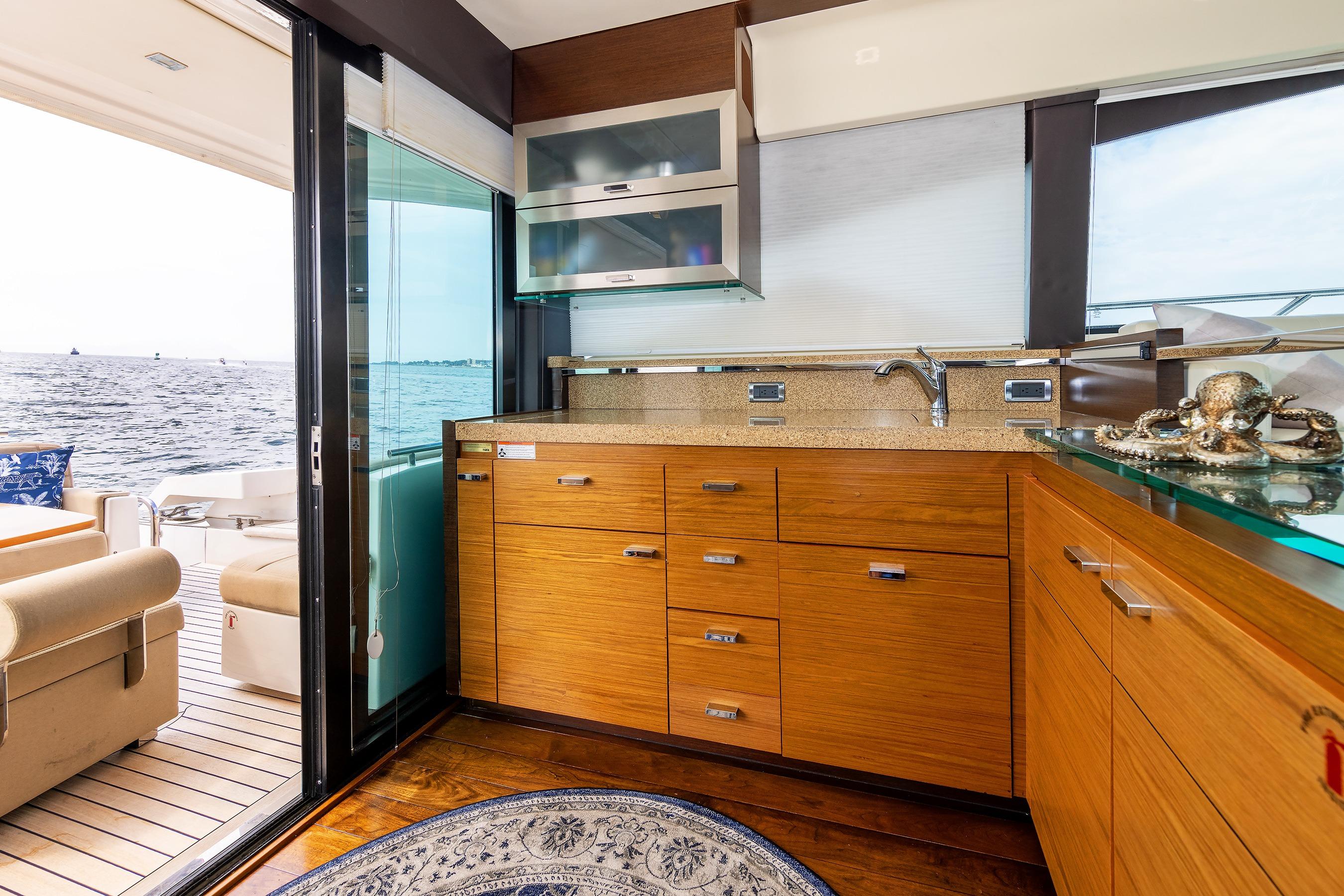 Luxurious interior of 2014 Tiara 5000 Coupe yacht with wooden cabinetry and ocean view.
