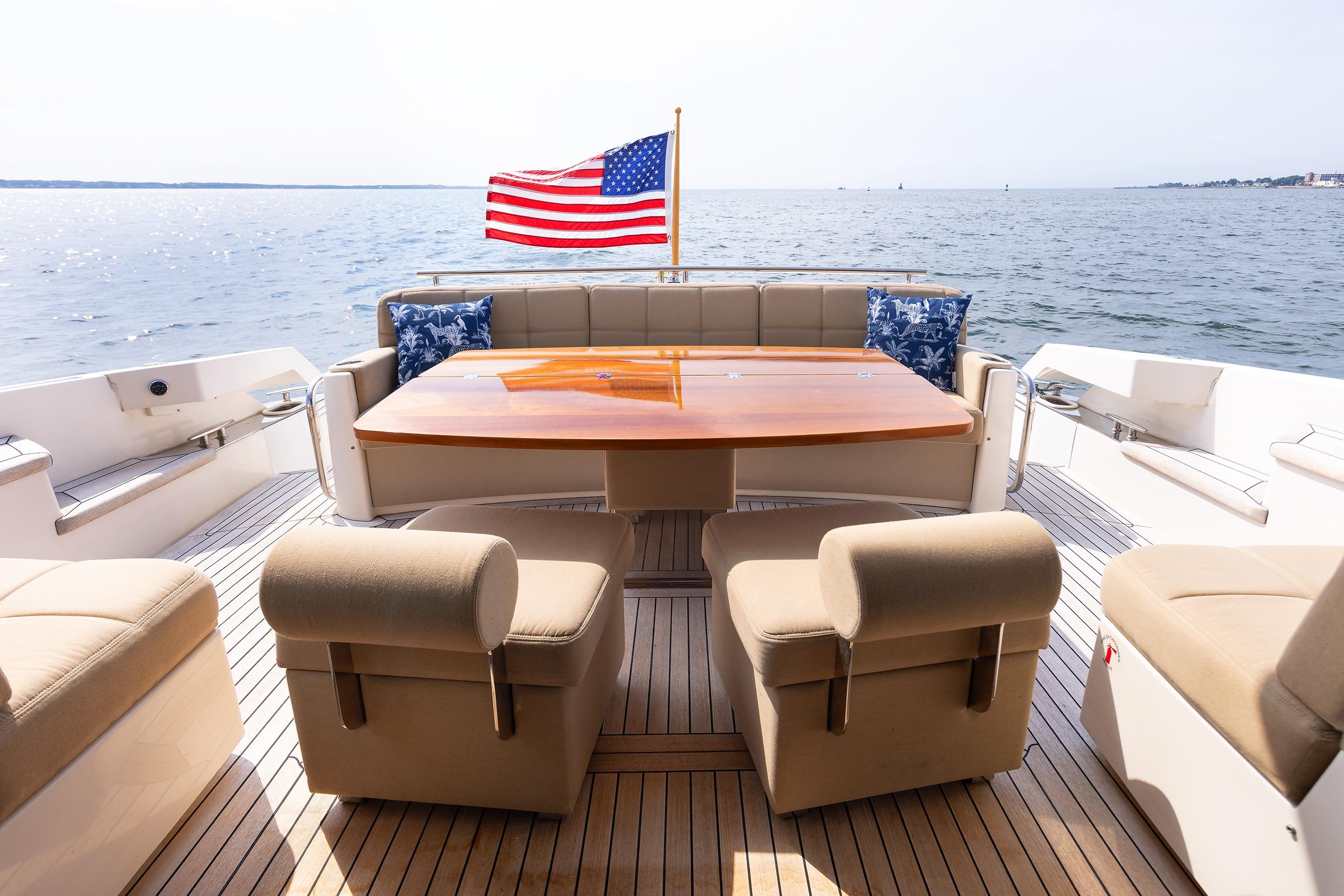 Luxurious 2014 Tiara 5000 Coupe yacht deck with seating, table, and American flag.