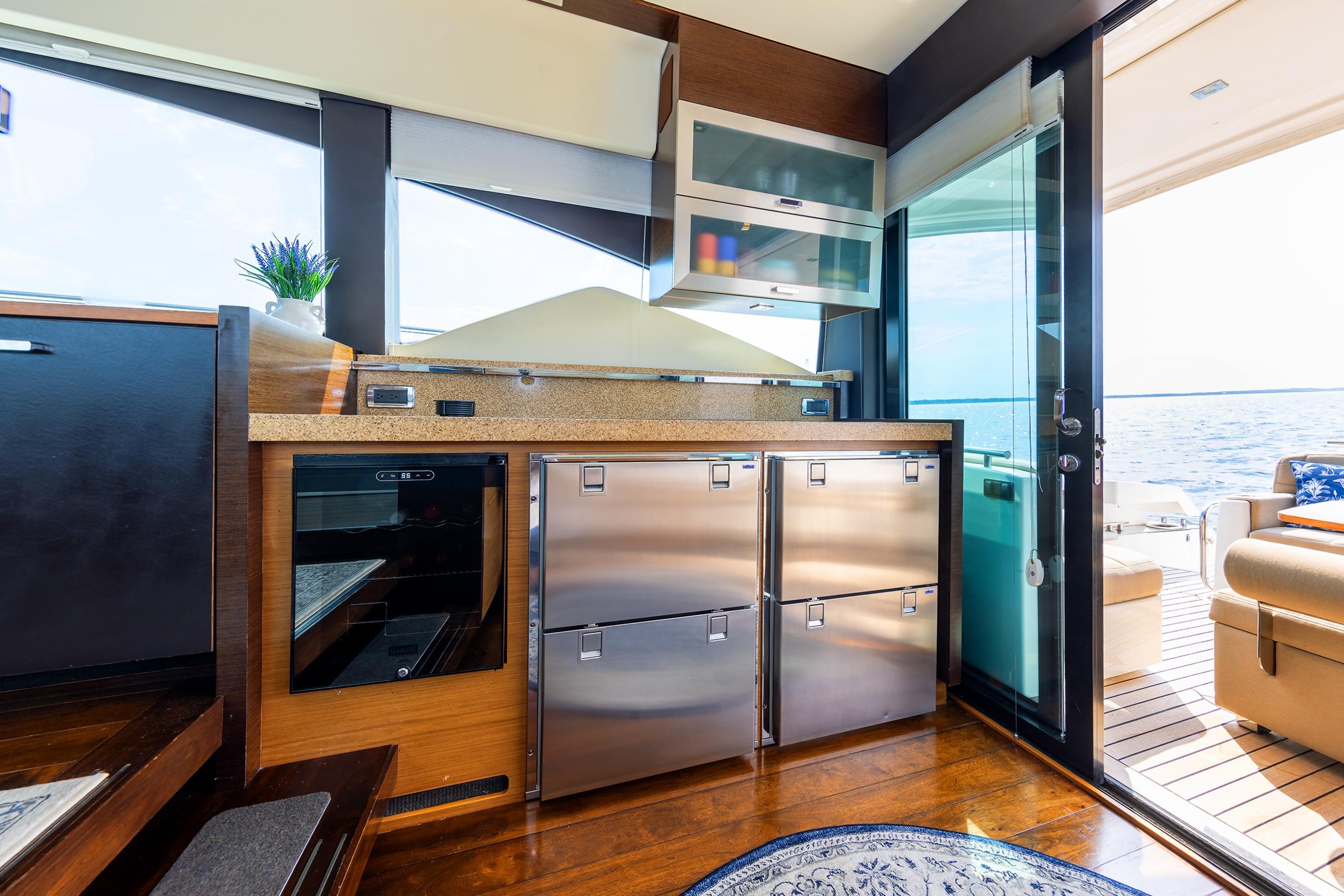 Luxurious interior of a 2014 Tiara 5000 Coupe yacht with modern kitchen and ocean view.