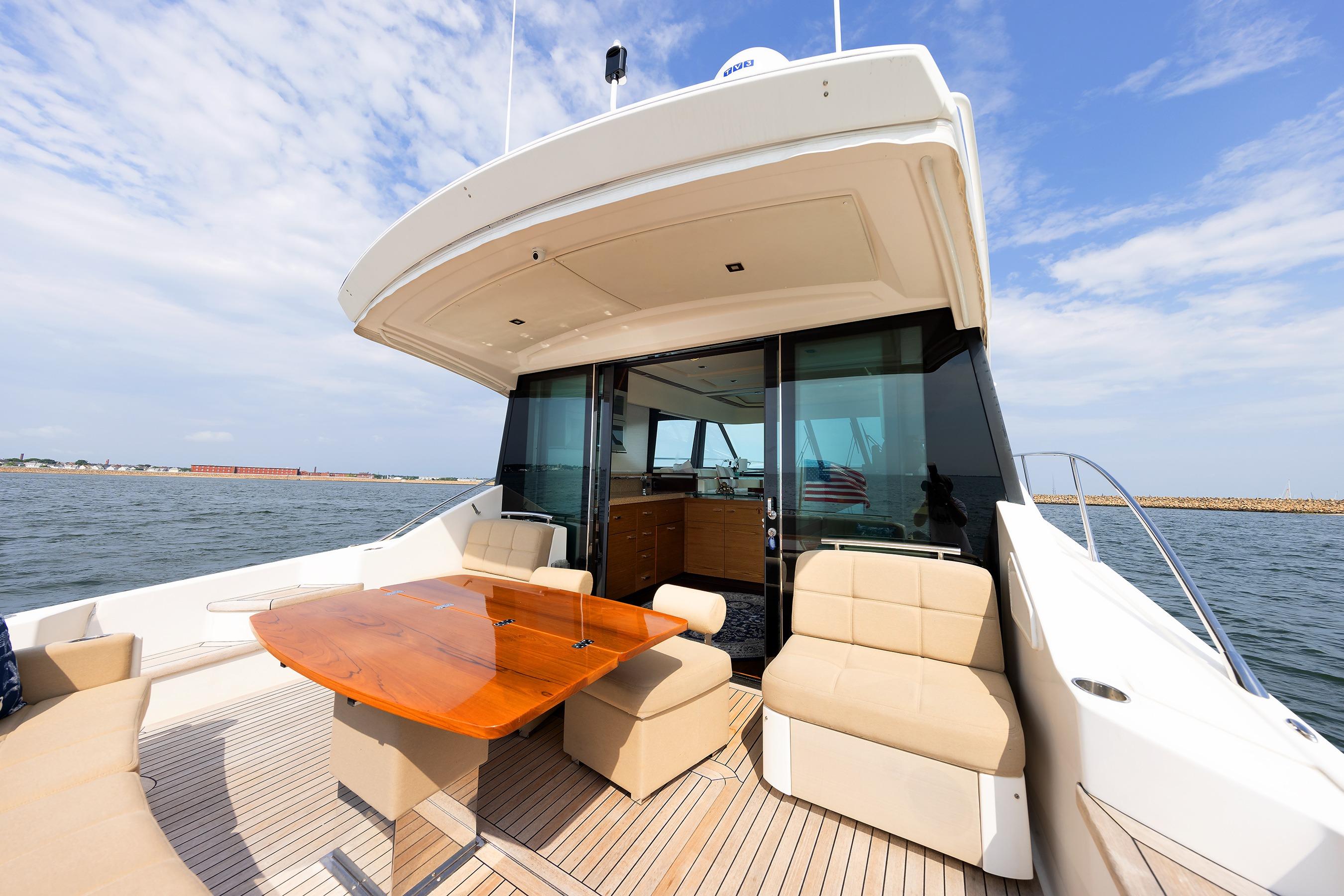 Luxurious 2014 Tiara 5000 Coupe yacht with elegant outdoor seating and ocean view.