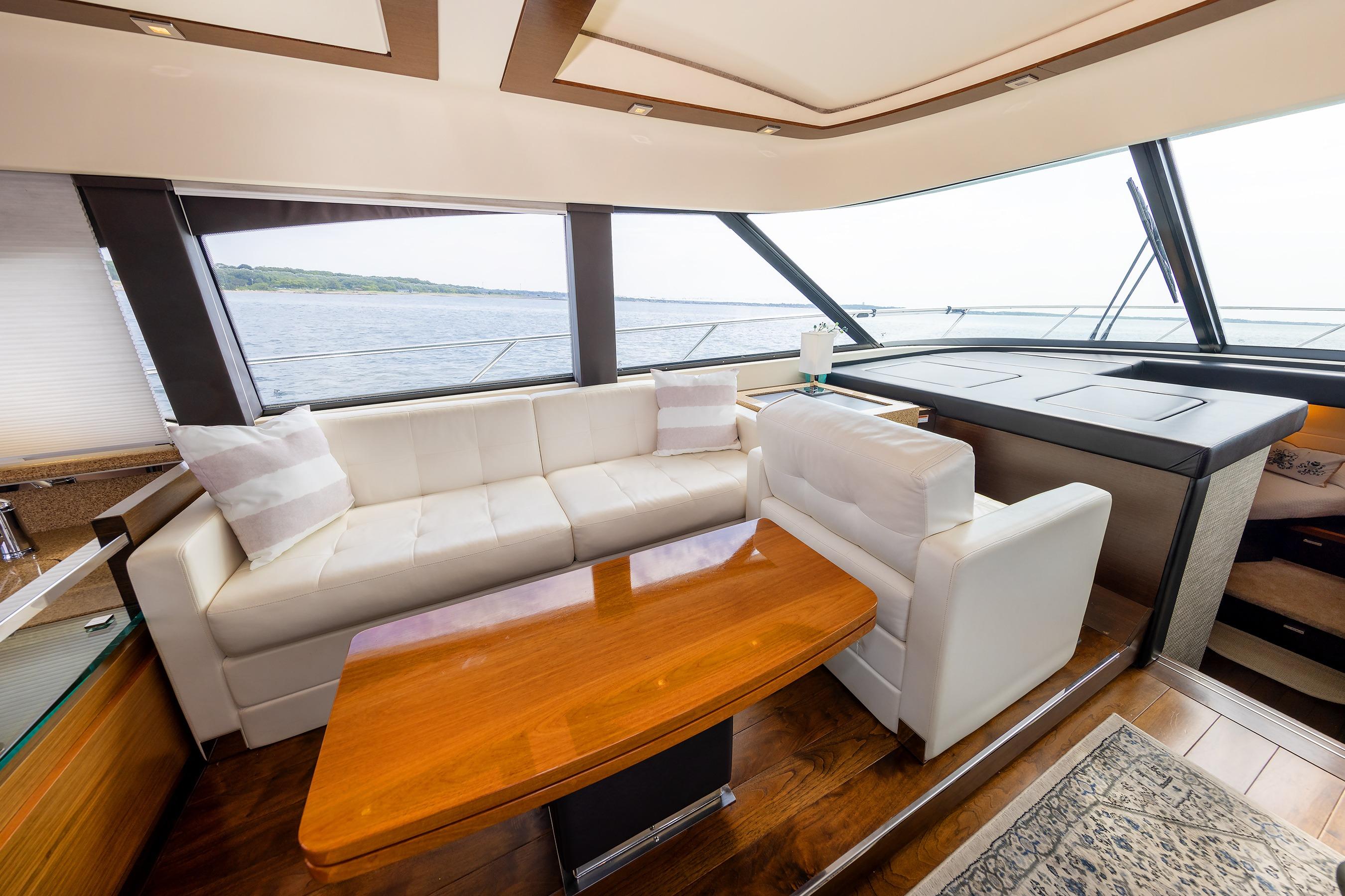 Luxurious interior of 2014 Tiara 5000 Coupe yacht with white seating and wooden table.