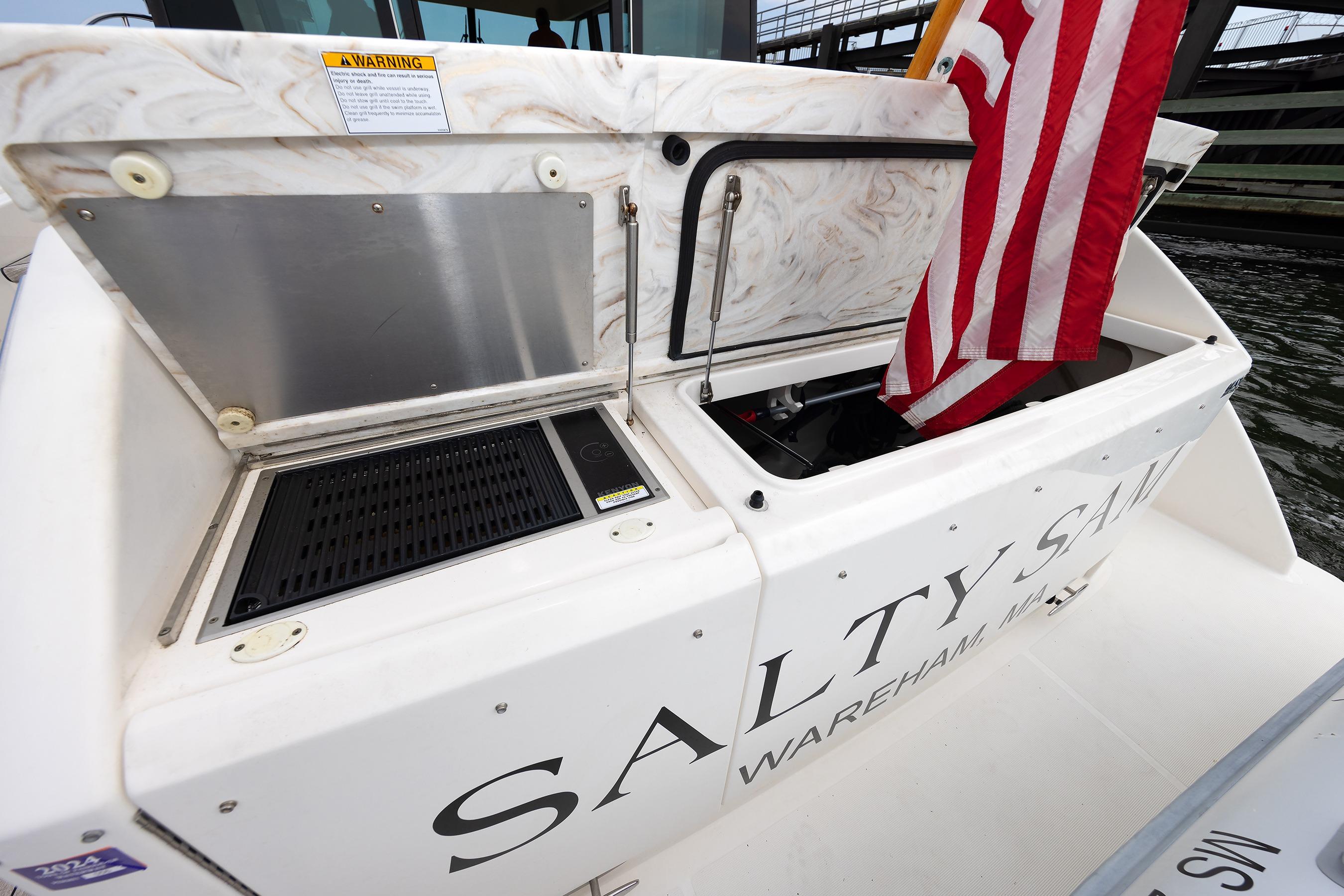 2014 Tiara 5000 Coupe boat stern with American flag and open storage compartments.