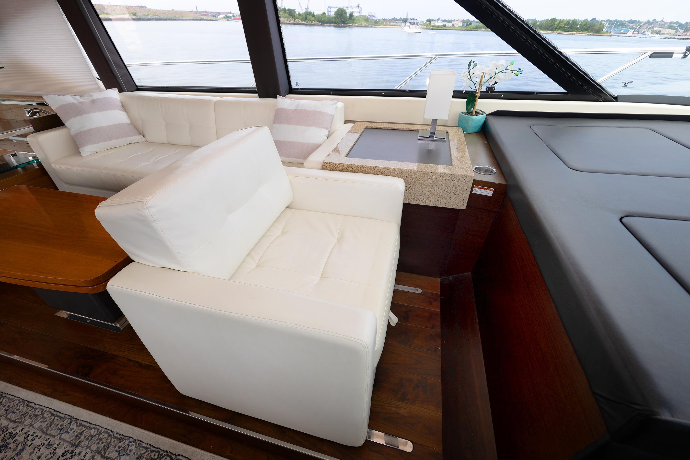 Luxurious interior of 2014 Tiara 5000 Coupe yacht with white seating and wooden accents.
