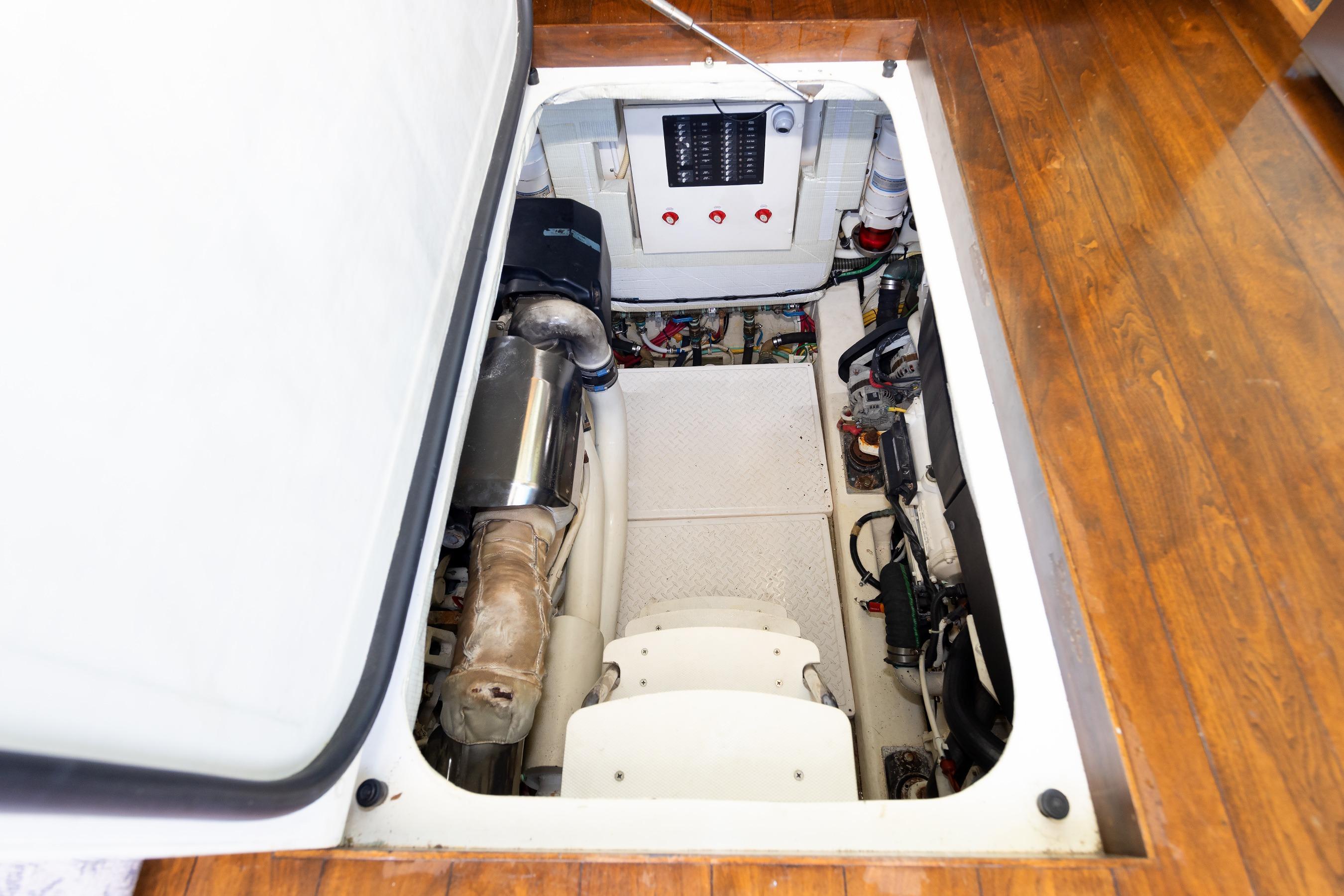 Engine compartment of a 2014 Tiara 5000 Coupe with visible components and wooden flooring.