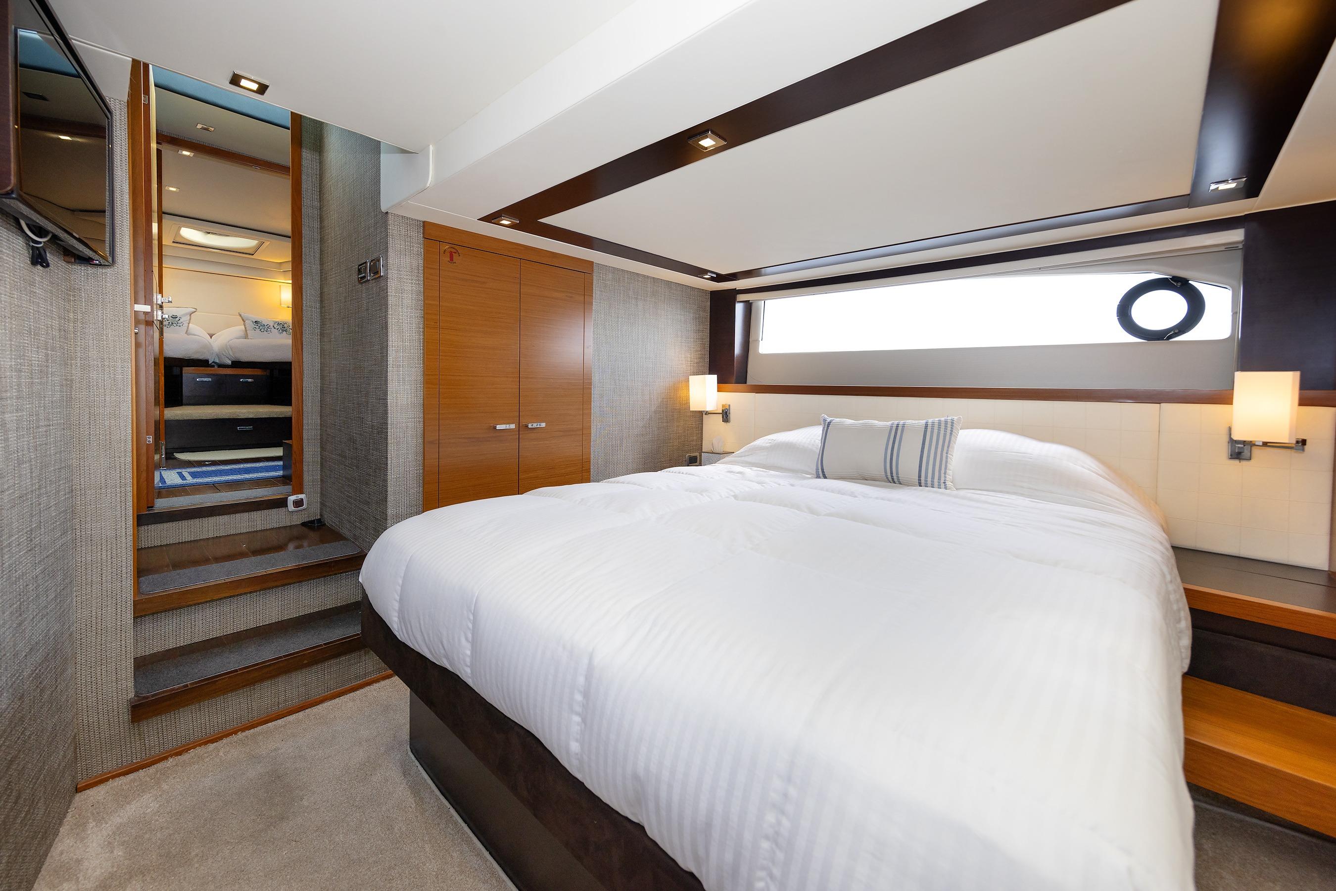 Luxurious bedroom interior of 2014 Tiara 5000 Coupe yacht with modern design.