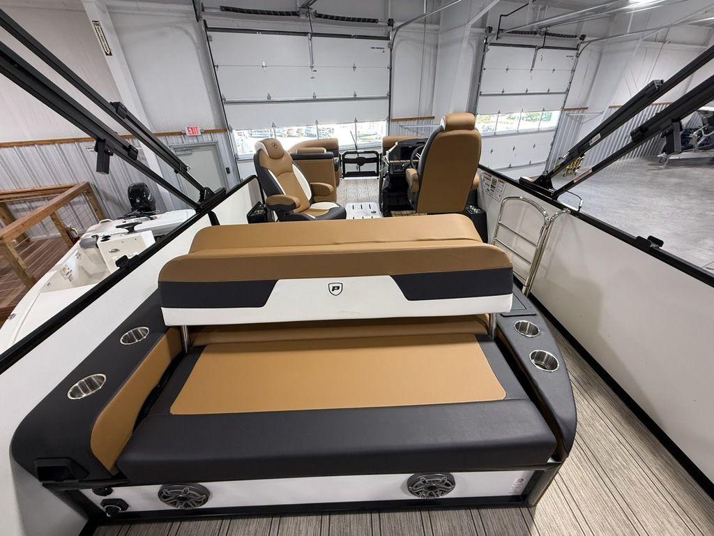 2025 Premier 230 Solaris RL boat interior with tan and black seating in a showroom.