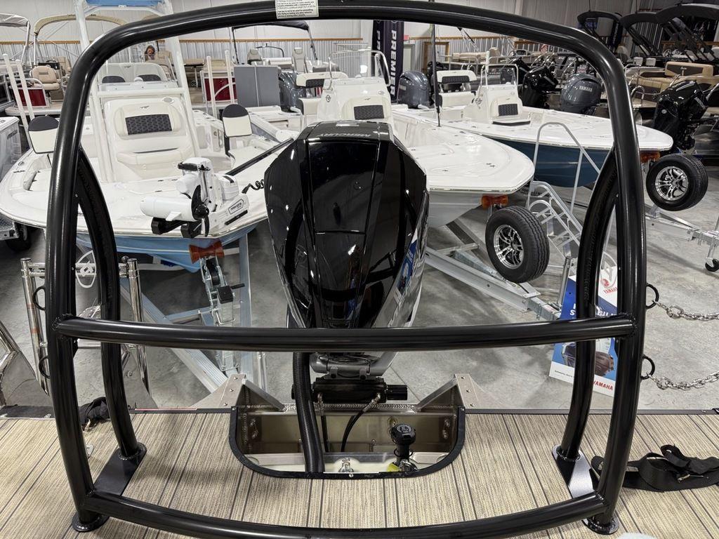 2025 Premier 230 Solaris RL boat engine in showroom, surrounded by other boats.