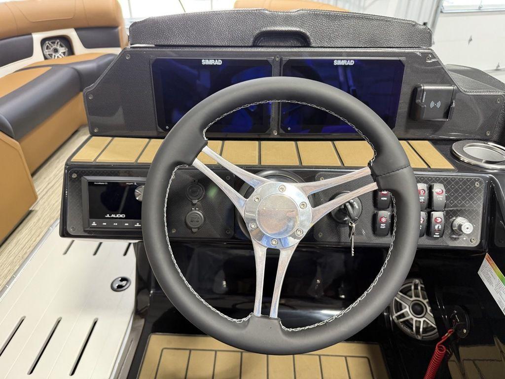 2025 Premier 230 Solaris RL boat dashboard with steering wheel and dual Simrad displays.