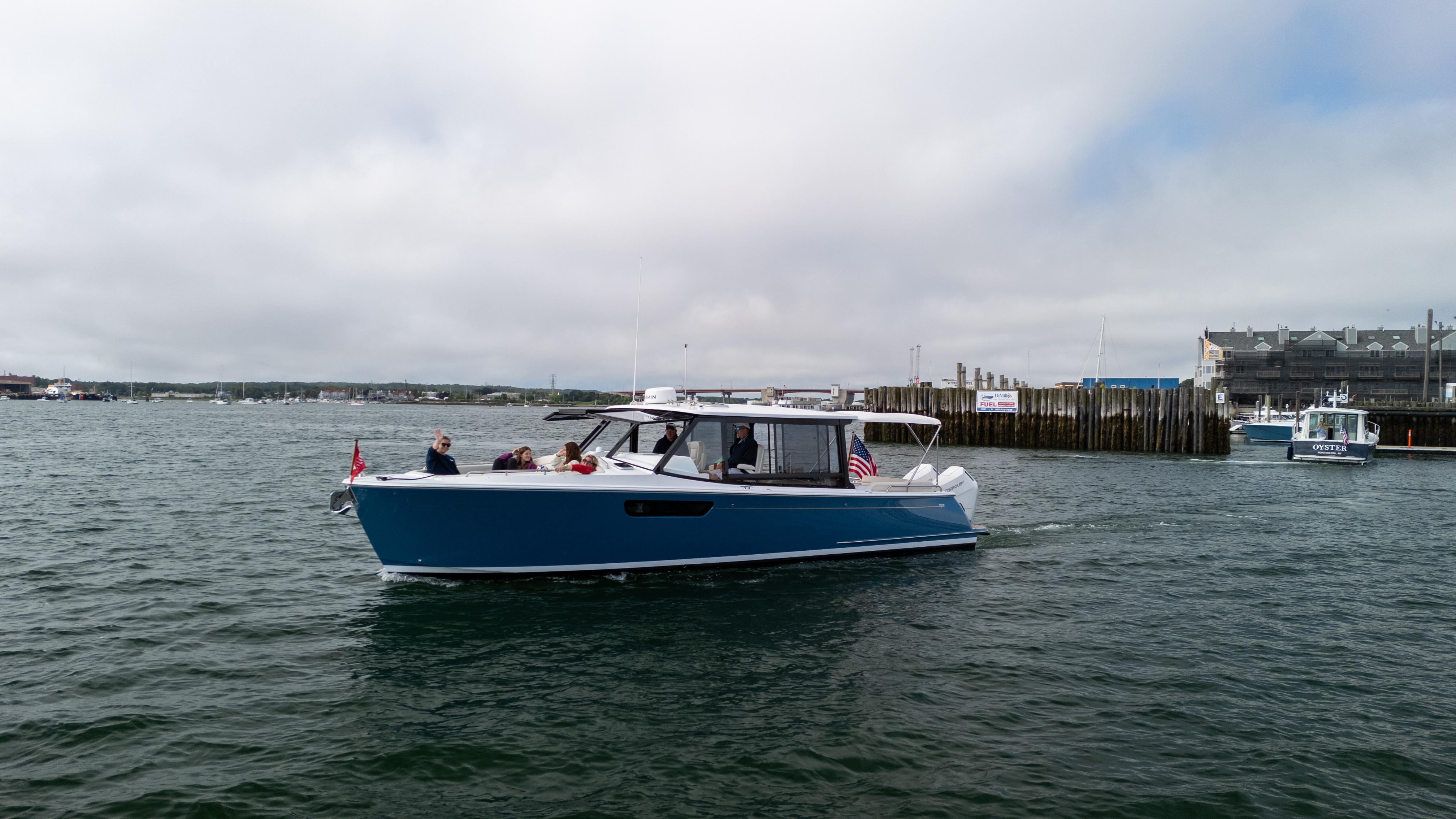 2025 MJM 3 boat cruising in a harbor with passengers on board.