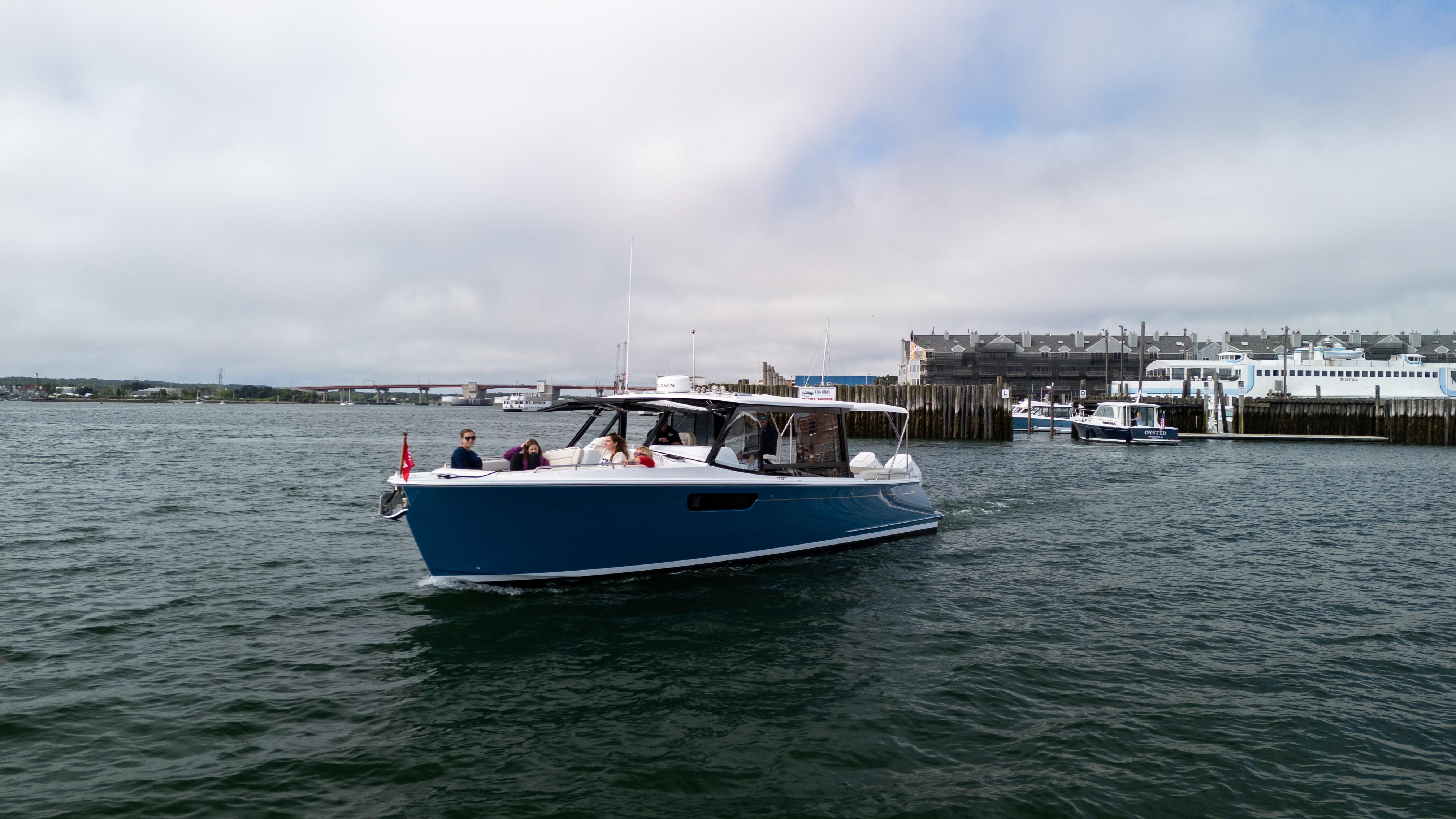 2025 MJM 3 boat cruising near a harbor with passengers onboard.