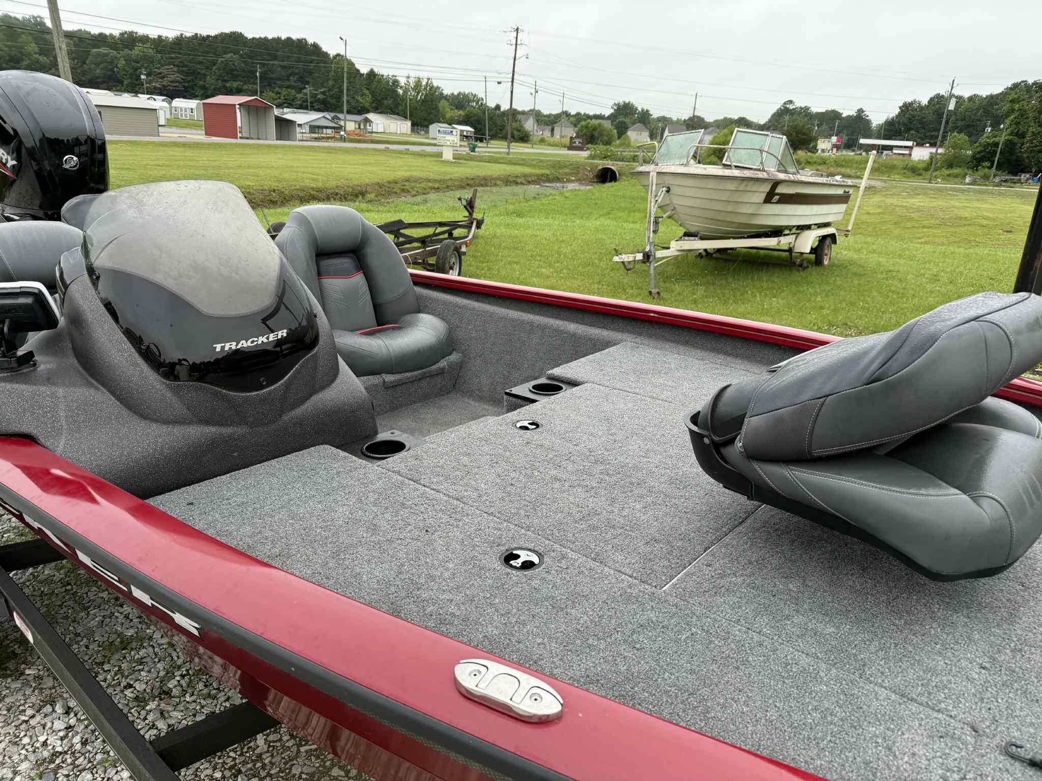 2022 Tracker Pro Team 175 TXW boat with gray seating and red trim, parked on grass.