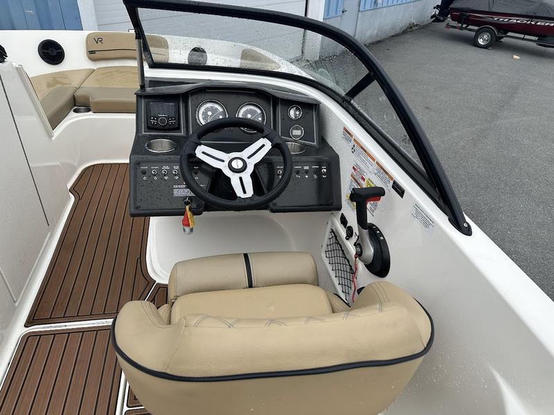 2023 Bayliner VR6 boat cockpit with beige seating and modern dashboard controls.