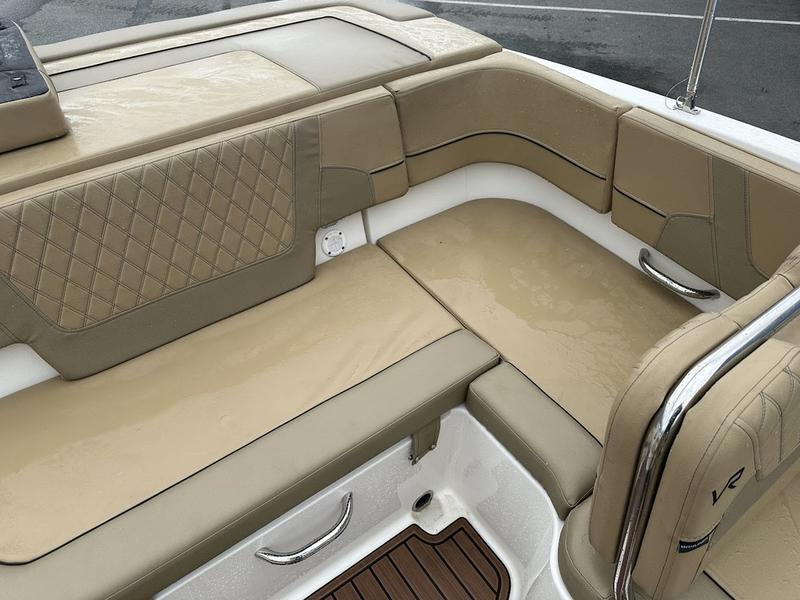 2023 Bayliner VR6 boat interior with beige cushioned seating and diamond stitching.