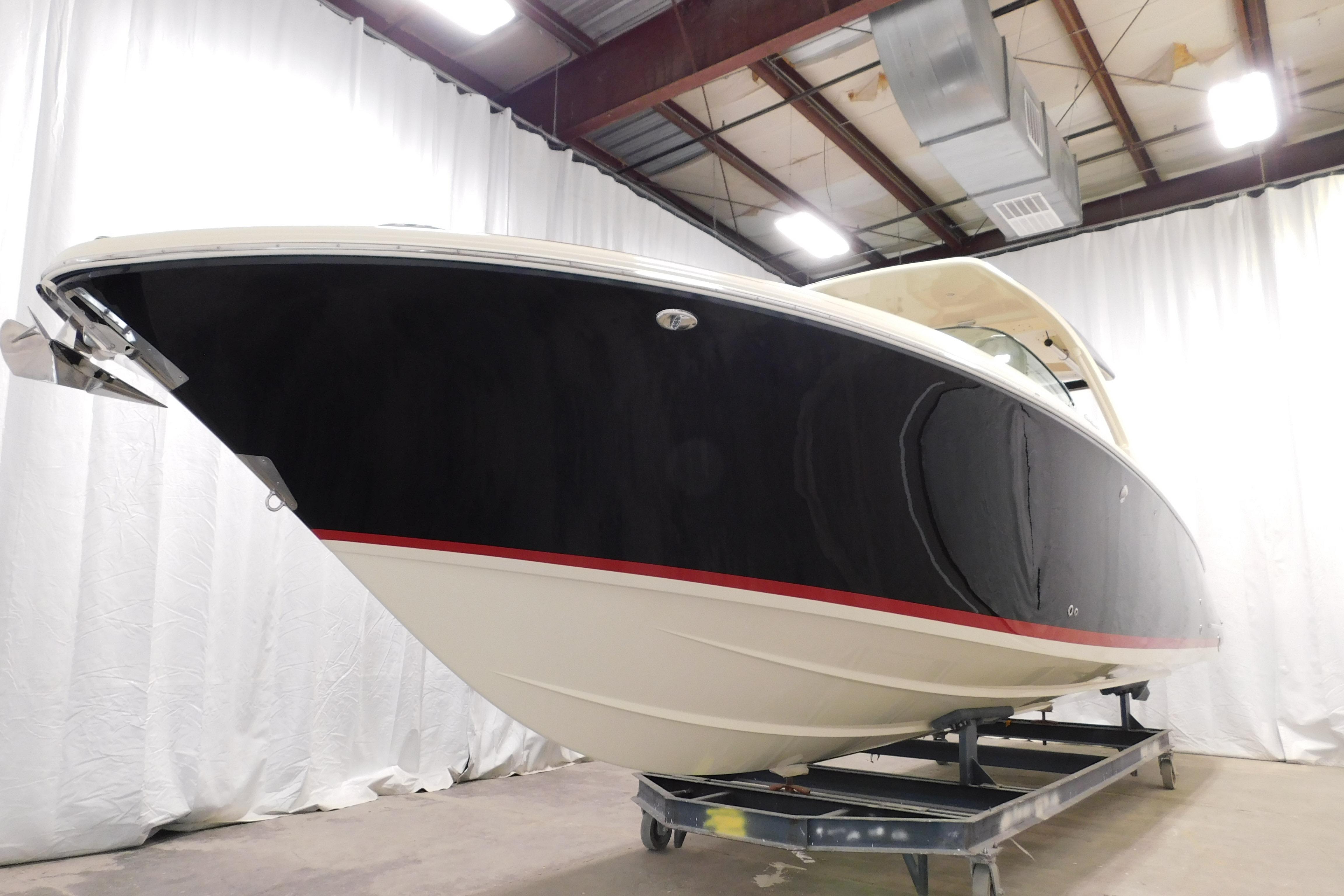 2021 Chris-Craft Launch 35 GT boat in showroom, black hull with red stripe.