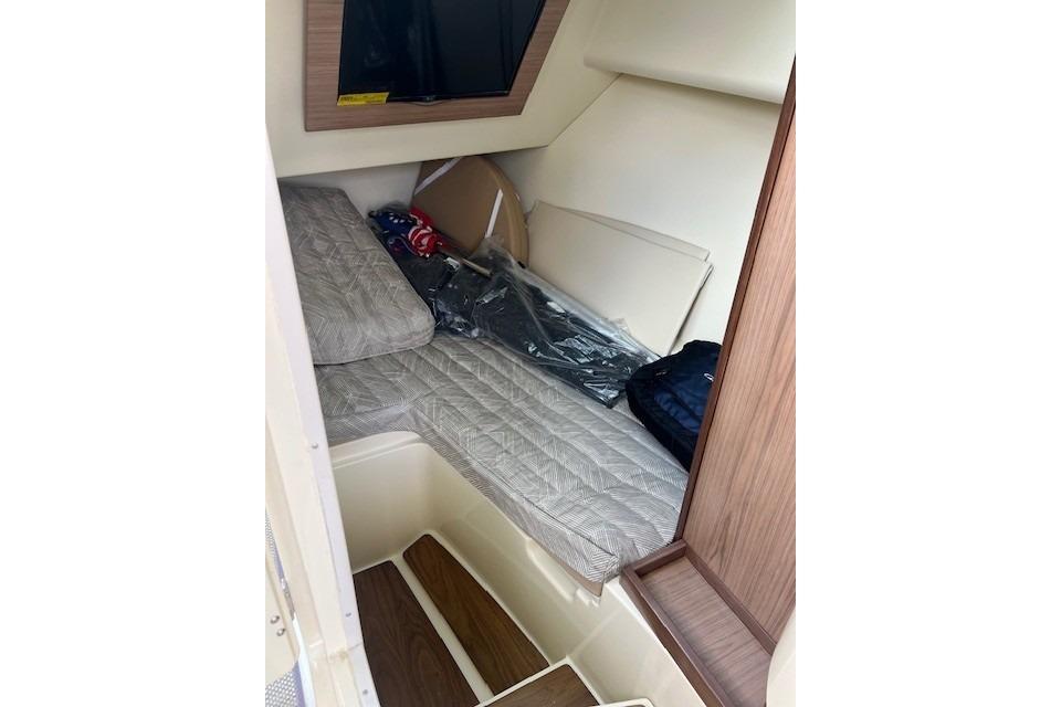 2021 Chris-Craft Launch 35 GT cabin interior with bed and wooden accents.