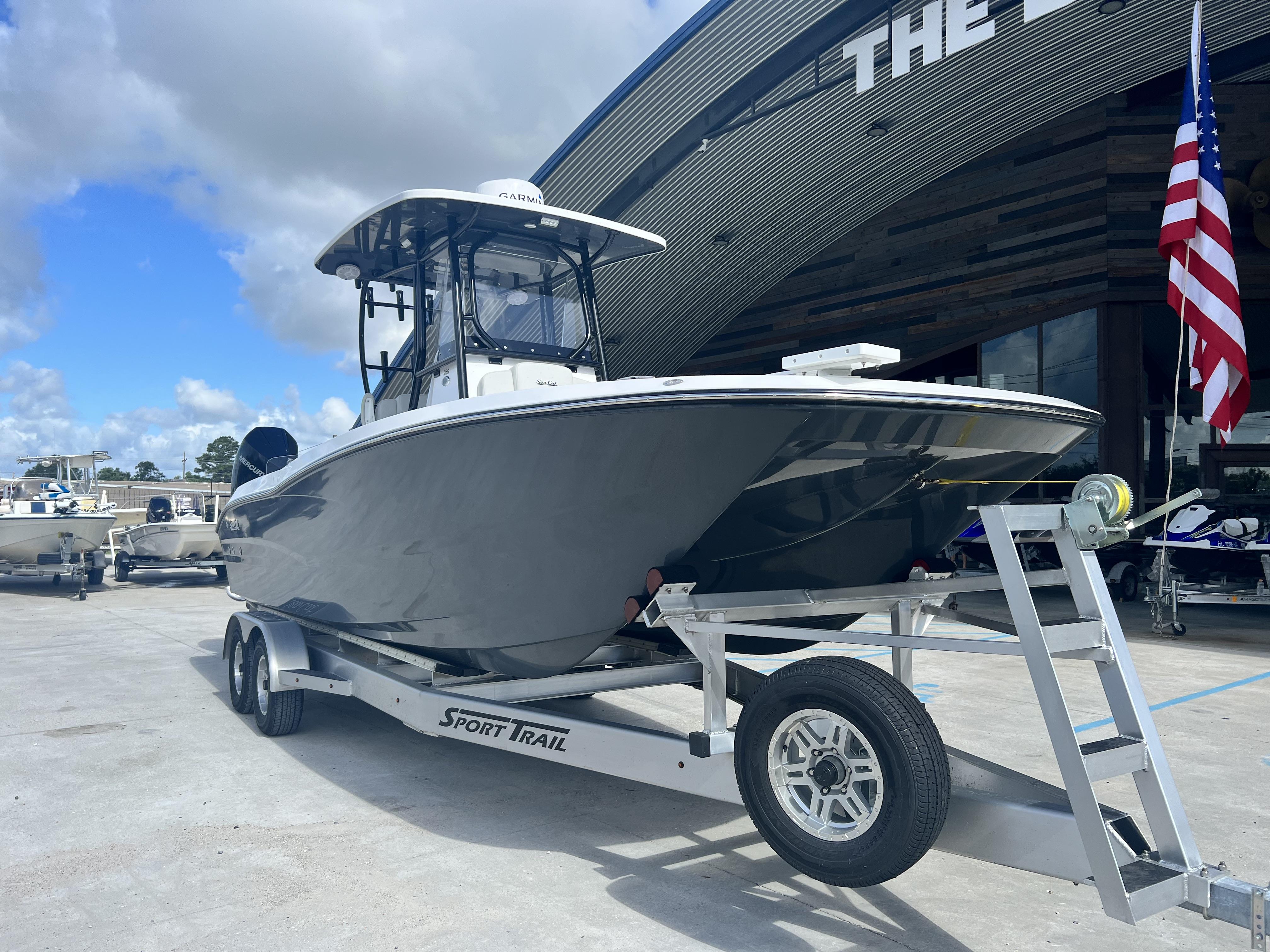 2023 Sea Cat 260 HC boat on trailer, parked outside dealership under blue sky.
