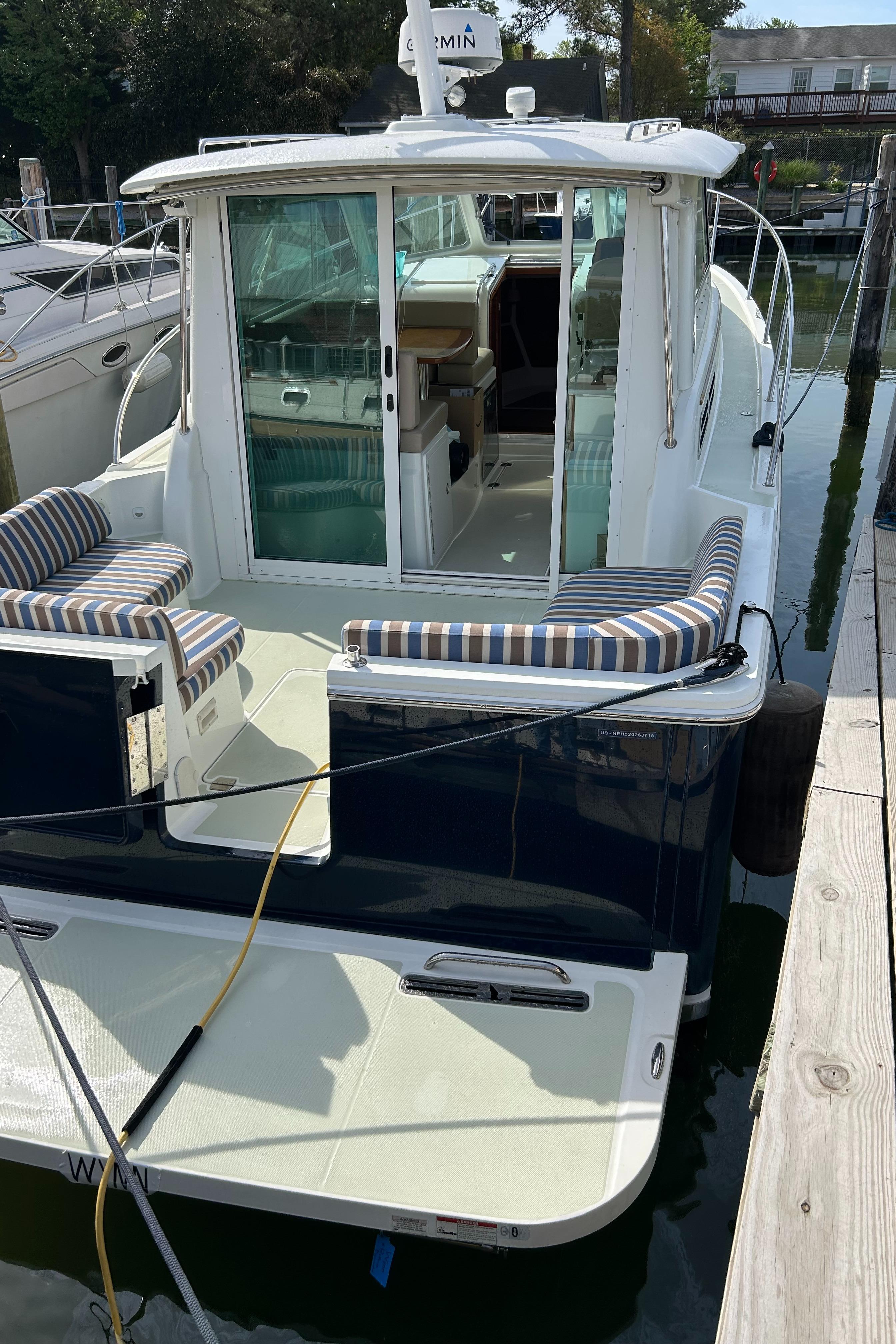 2018 Back Cove 32 boat docked, featuring striped seating and a sleek design.
