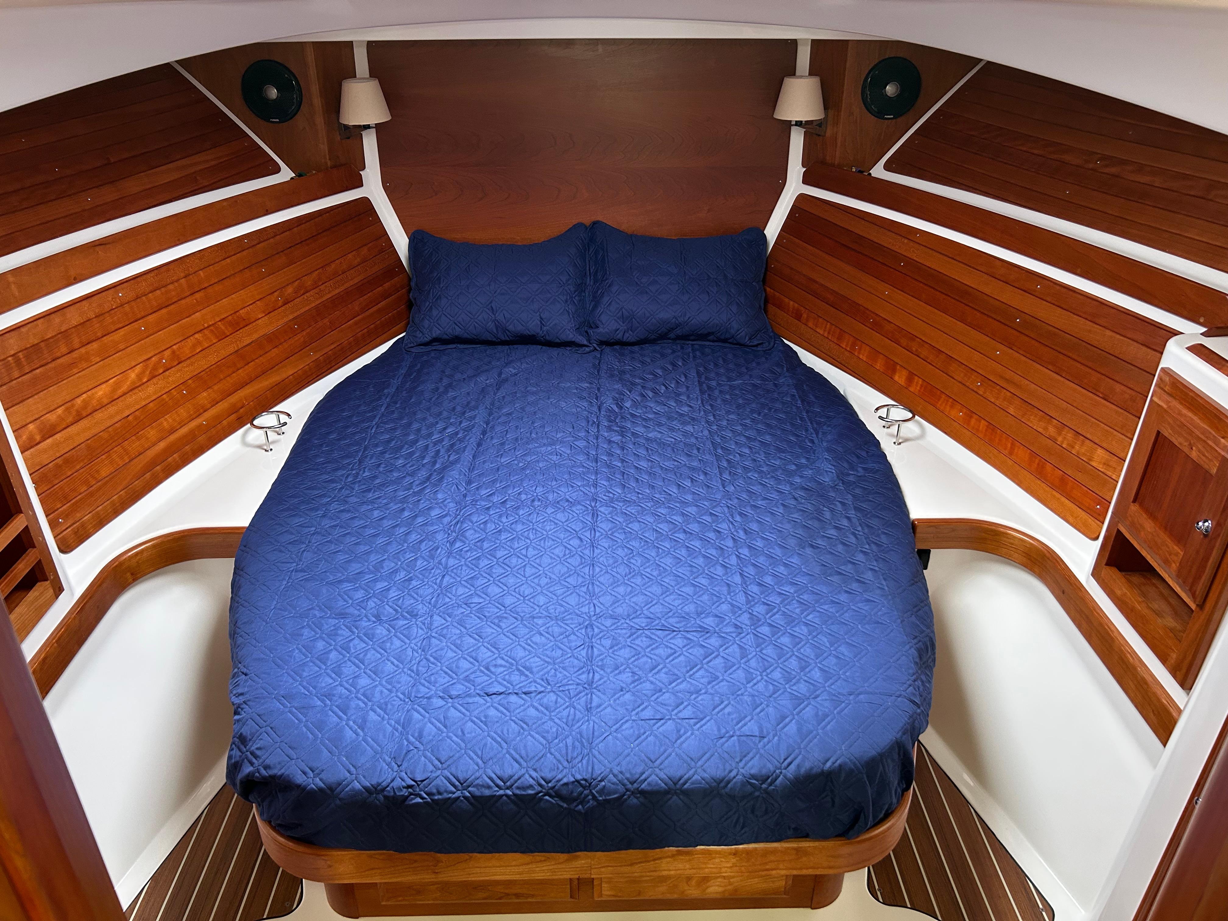 2018 Back Cove 32 cabin interior with blue bedding and wooden accents.
