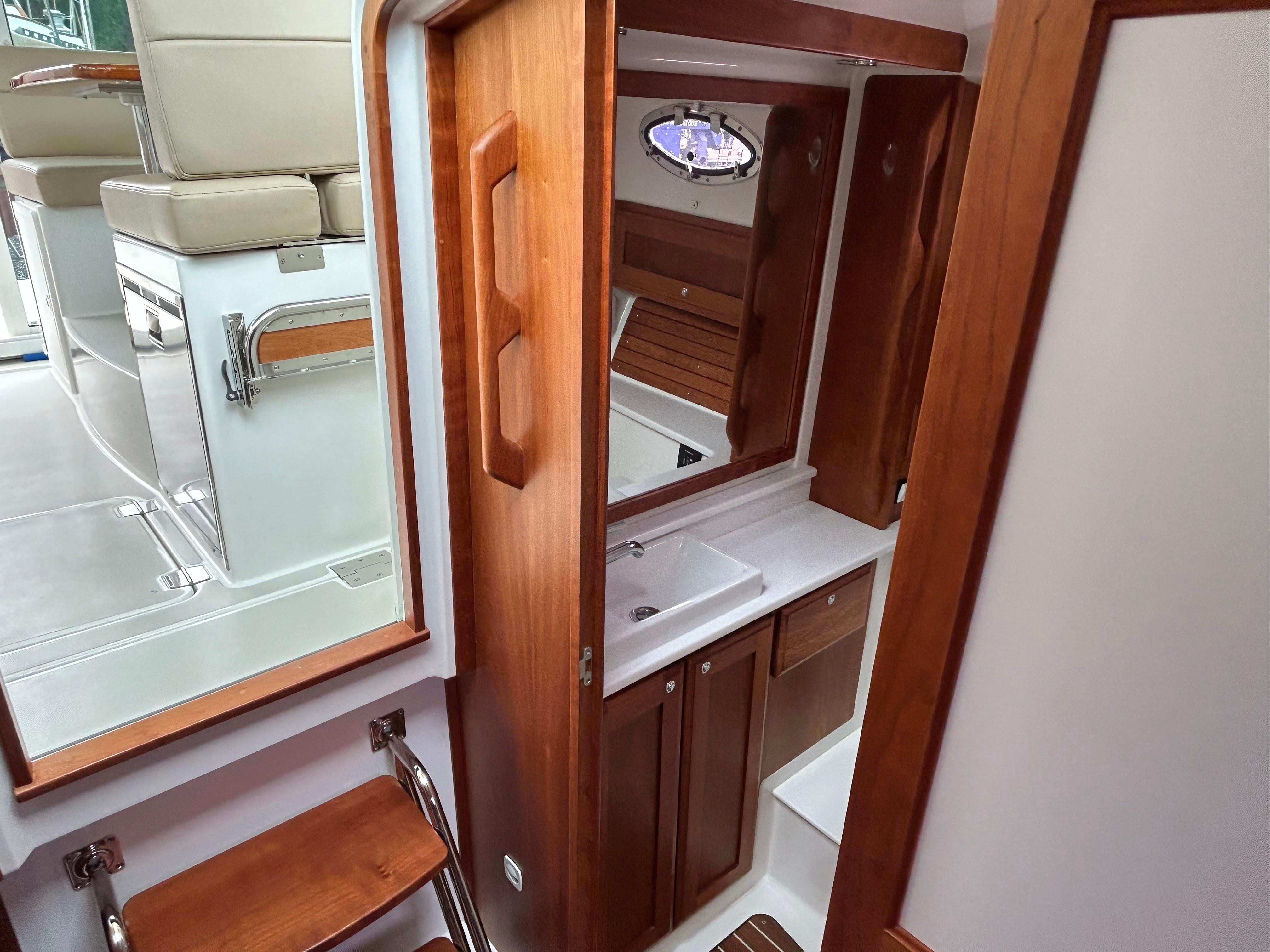 2018 Back Cove 32 yacht interior with wooden cabinetry and compact bathroom.