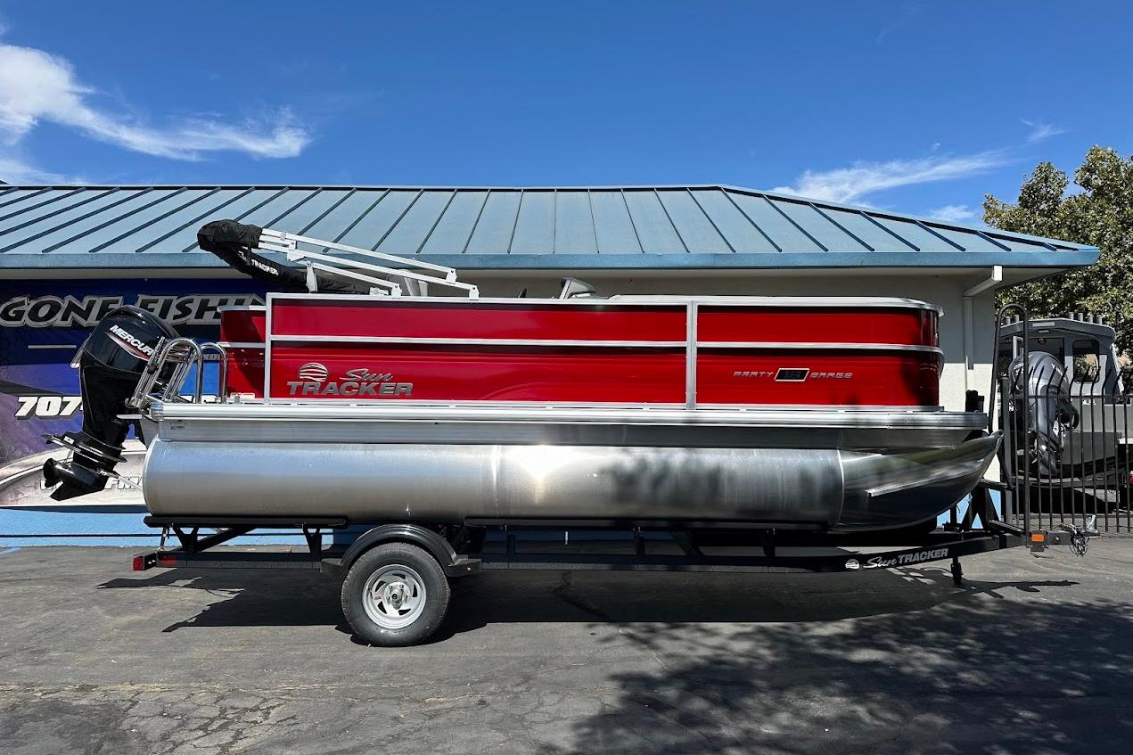 2026 Sun Tracker Party Barge 18 DLX pontoon boat on trailer, parked outdoors.