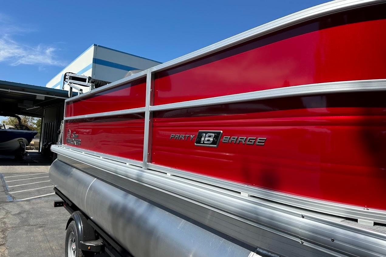 2026 Sun Tracker Party Barge 18 DLX pontoon boat with vibrant red exterior.