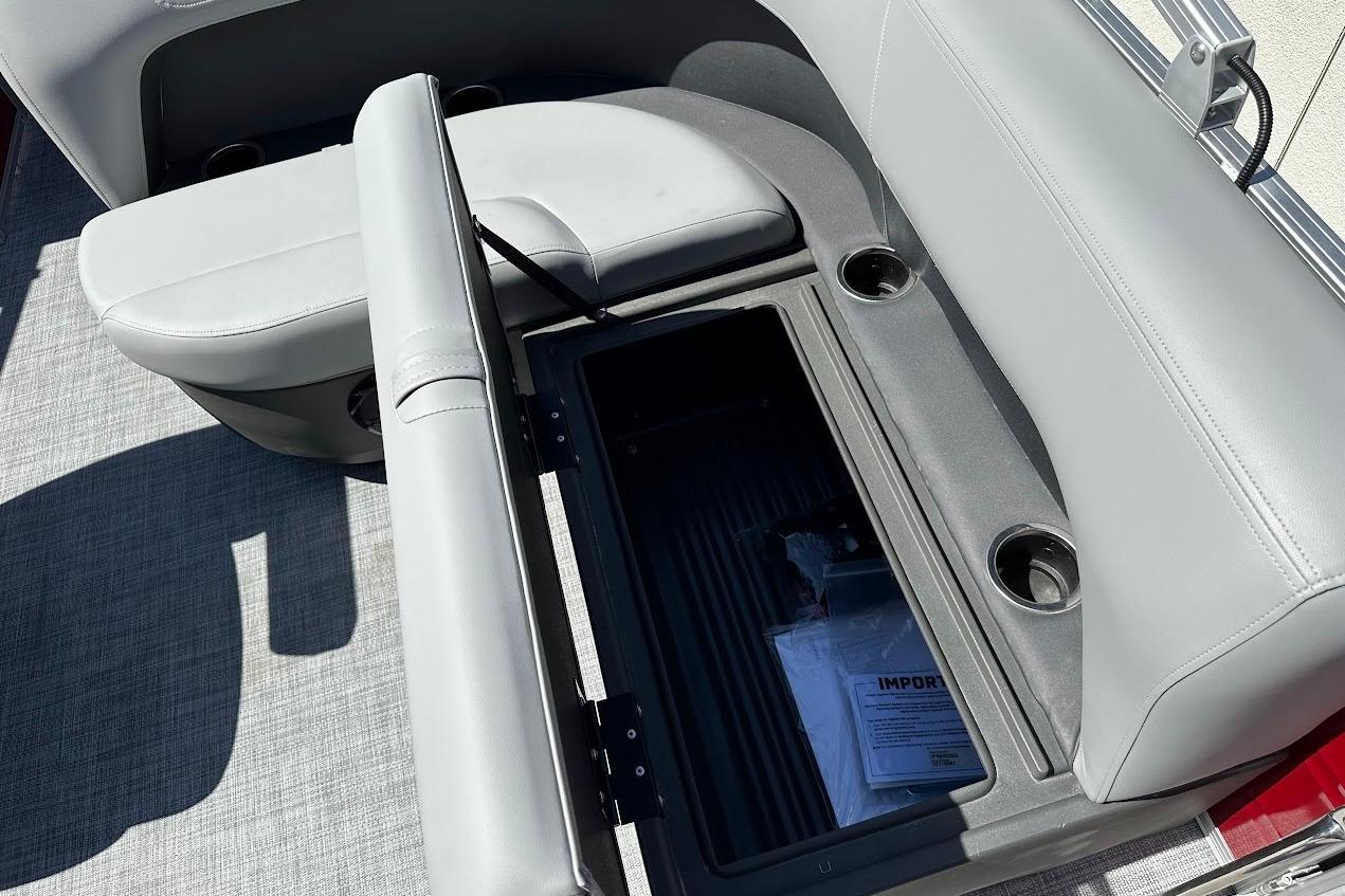 2026 Sun Tracker Party Barge 18 DLX with open storage compartment and cup holders.
