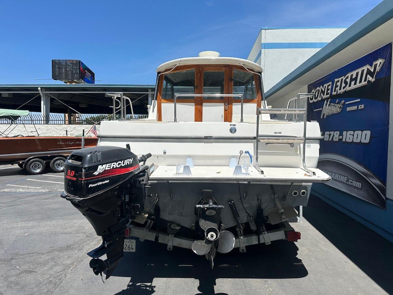1992 Bayliner 2359 Trophy boat with Mercury outboard motor, parked outdoors.