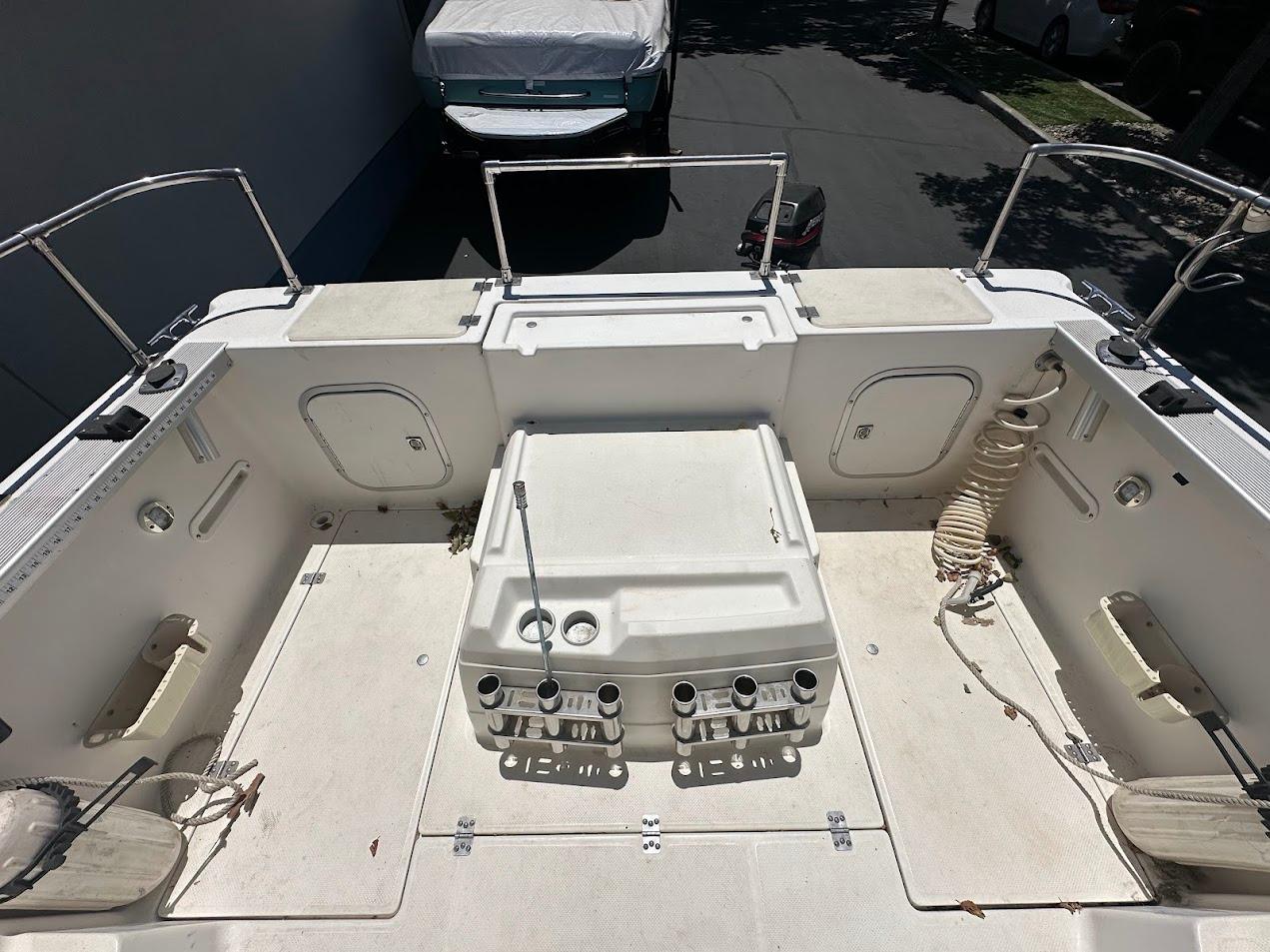 1992 Bayliner 2359 Trophy boat deck with storage compartments and fishing rod holders.