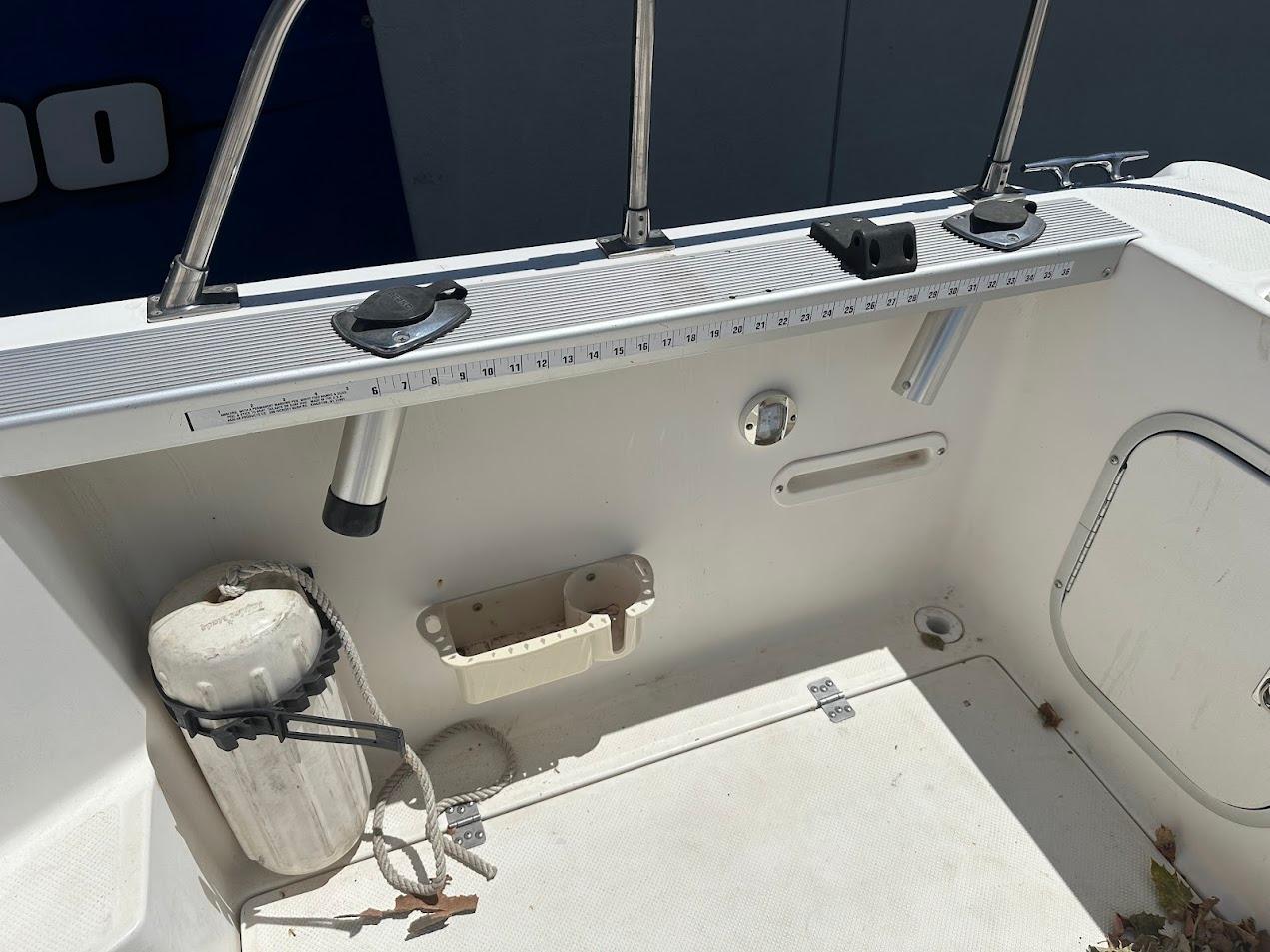 Interior view of a 1992 Bayliner 2359 Trophy boat, featuring fishing rod holders and a measuring ruler.