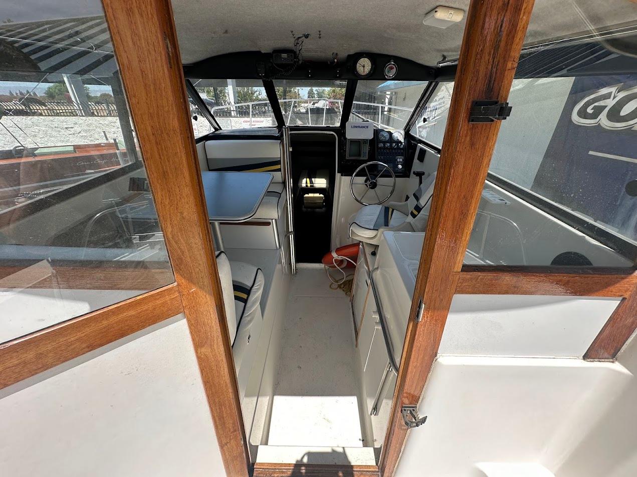 Interior view of a 1992 Bayliner 2359 Trophy boat, featuring wooden accents and steering area.
