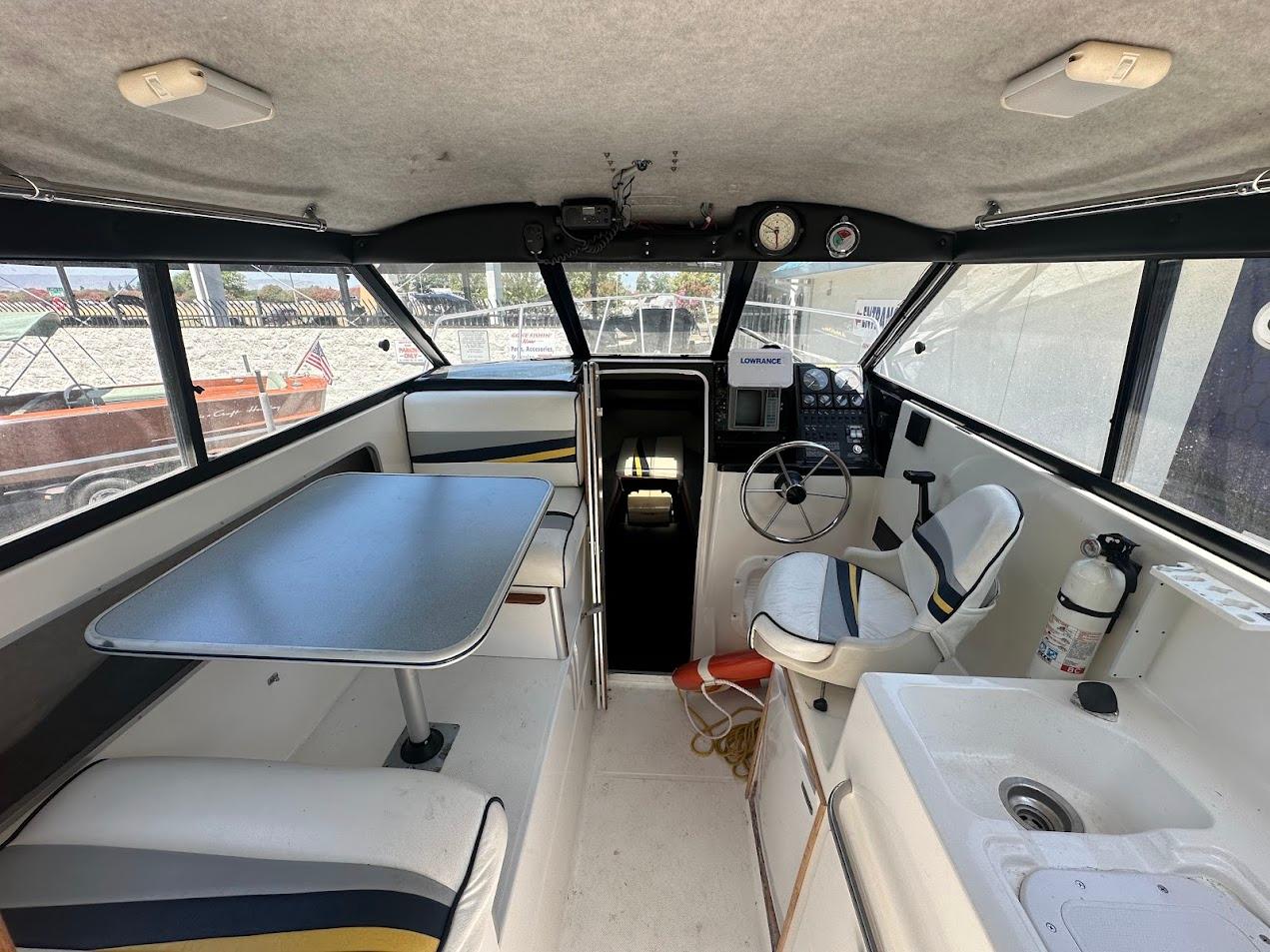 Interior of 1992 Bayliner 2359 Trophy boat with seating, table, and steering console.