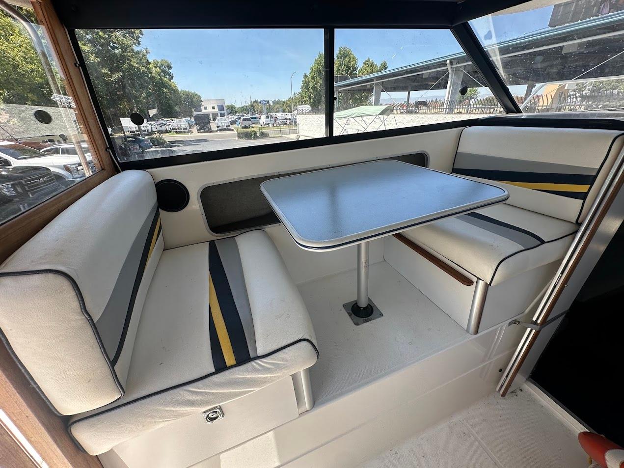 Interior of a 1992 Bayliner 2359 Trophy boat with cushioned seating and table.