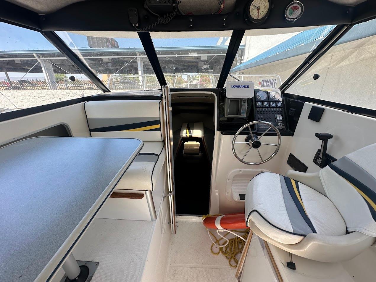 Interior of 1992 Bayliner 2359 Trophy boat with steering wheel and seating area.