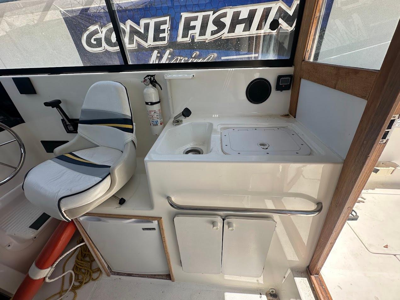 Interior of 1992 Bayliner 2359 Trophy boat with seating and sink area.