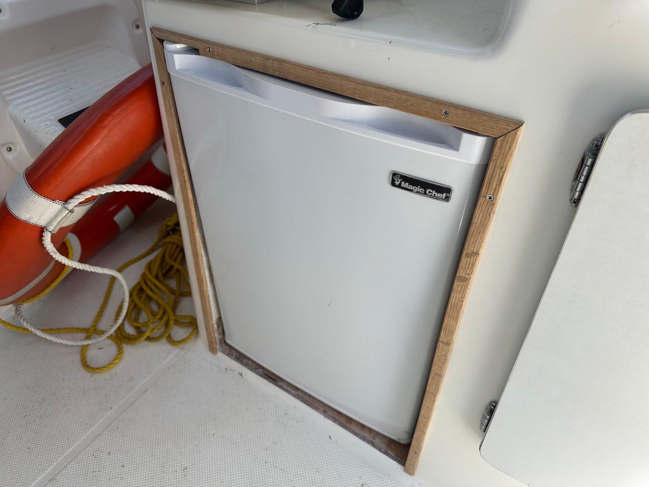 Magic Chef fridge on 1992 Bayliner 2359 Trophy boat with life preserver and rope nearby.