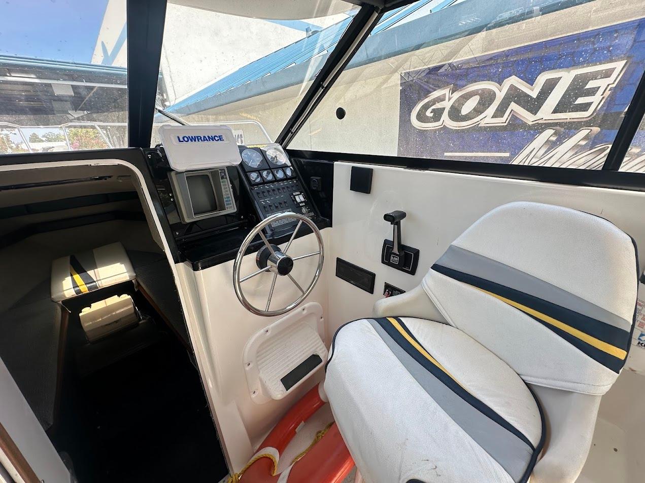 Interior of 1992 Bayliner 2359 Trophy boat with steering wheel and Lowrance navigation system.