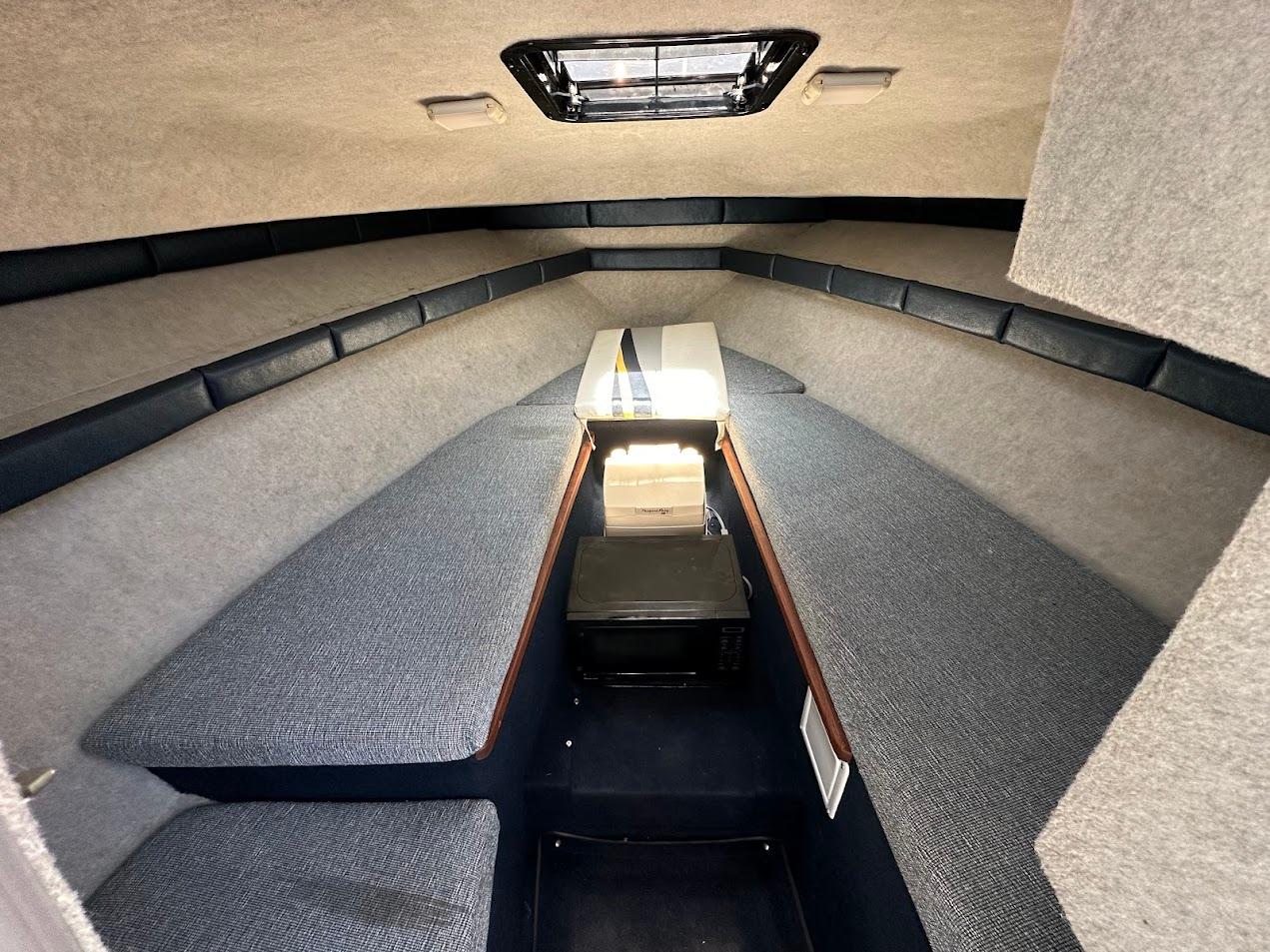 Interior cabin of 1992 Bayliner 2359 Trophy boat, featuring seating and storage.