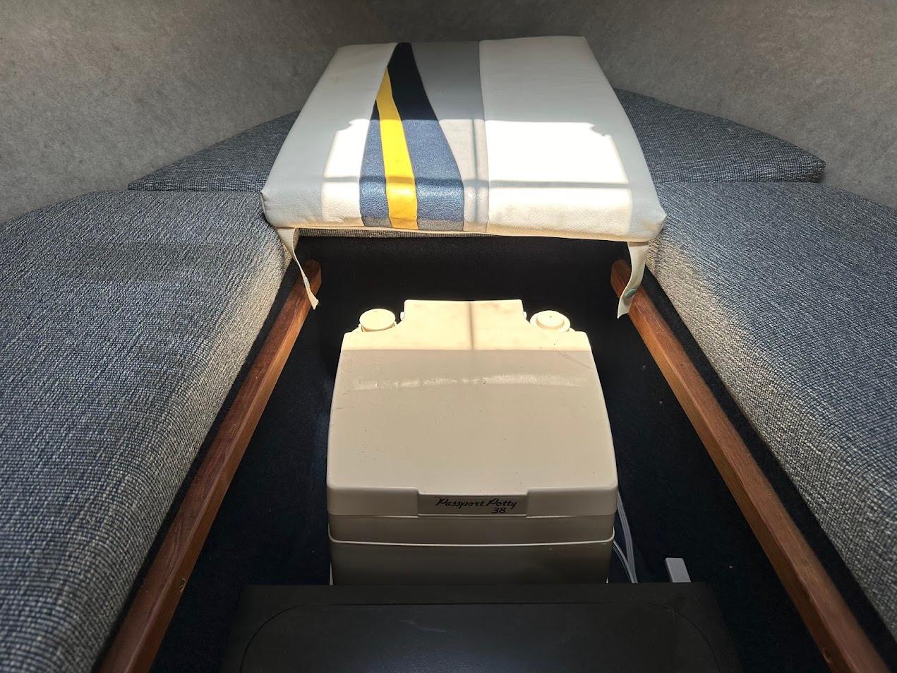 Interior of 1992 Bayliner 2359 Trophy boat with portable toilet and cushioned seating.