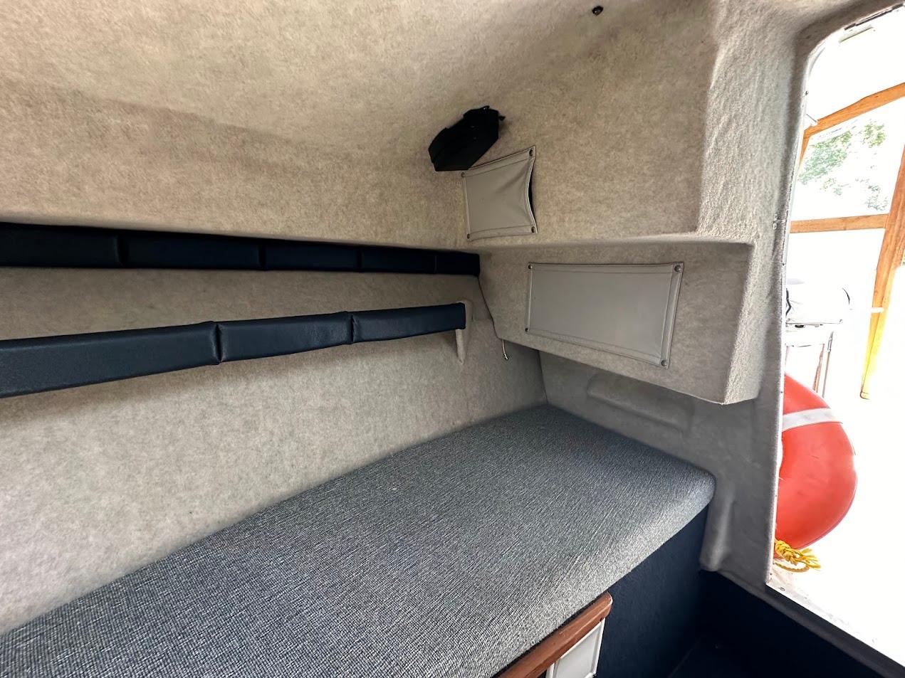 1992 Bayliner 2359 Trophy cabin interior with cushioned seating and storage compartments.
