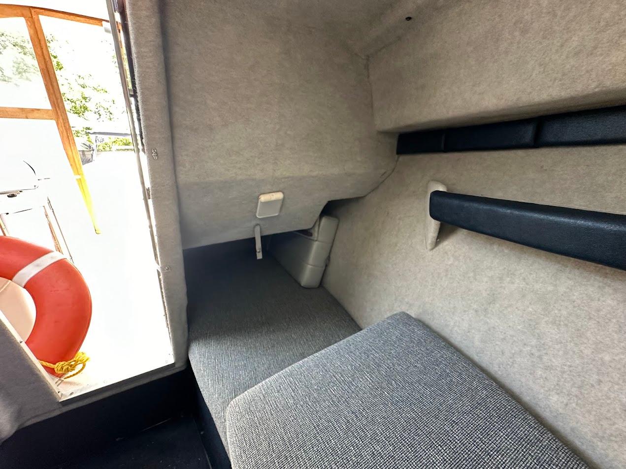 Interior cabin of 1992 Bayliner 2359 Trophy boat with seating and life preserver.