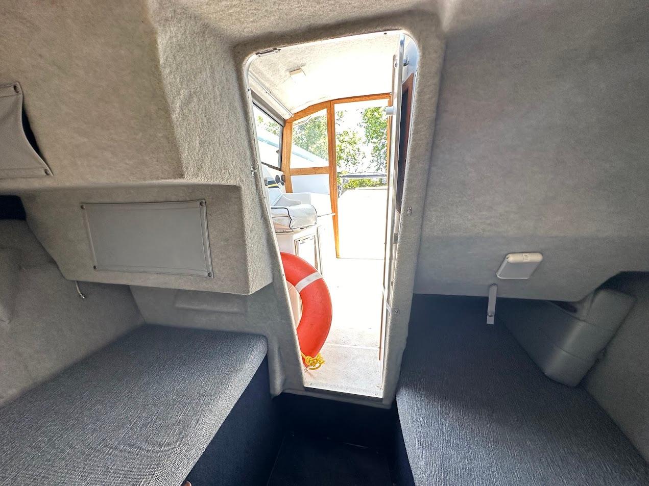 Interior cabin of 1992 Bayliner 2359 Trophy boat with seating and life preserver.