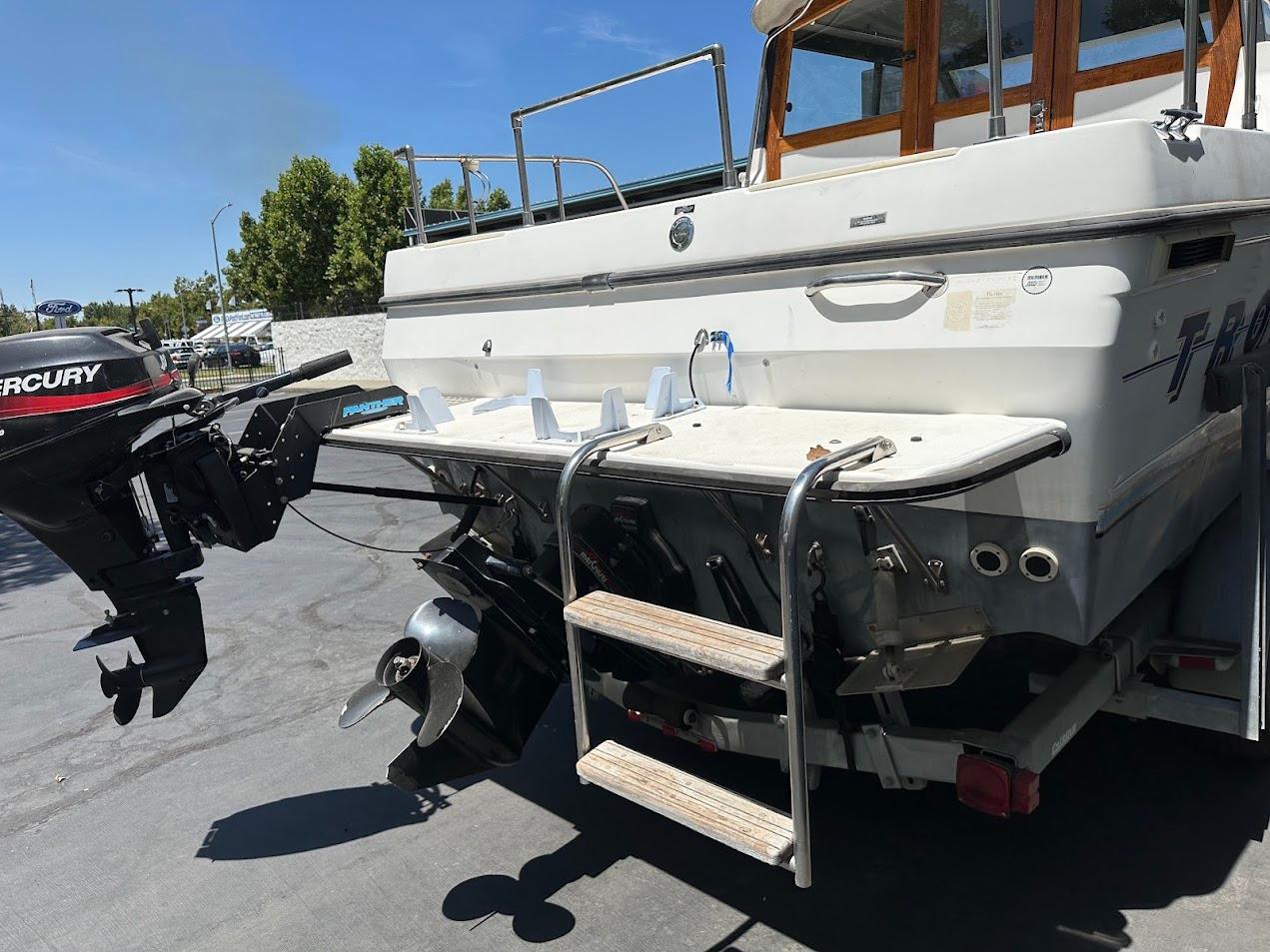1992 Bayliner 2359 Trophy boat with Mercury outboard motor, rear view showing propeller and swim platform.
