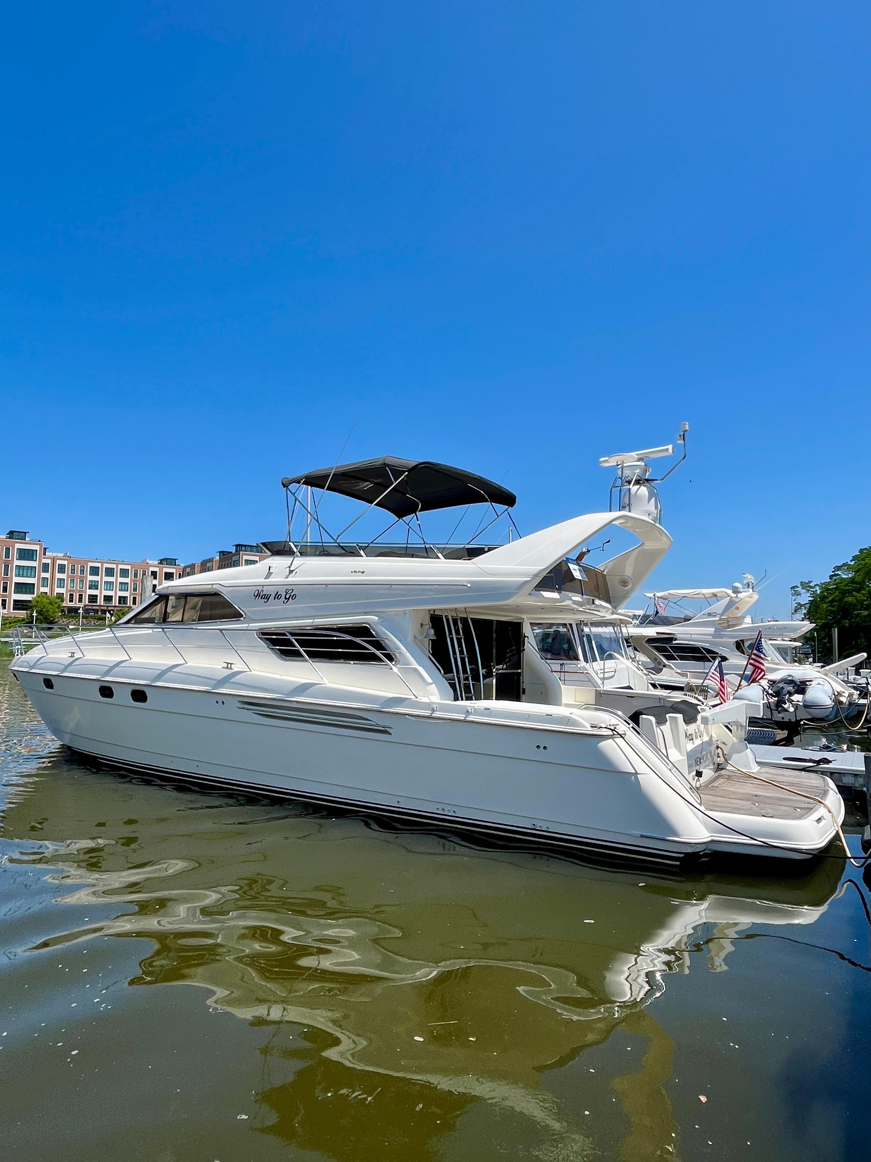 1999 Viking Sport Cruisers 61 Flybridge yacht docked under clear blue sky.