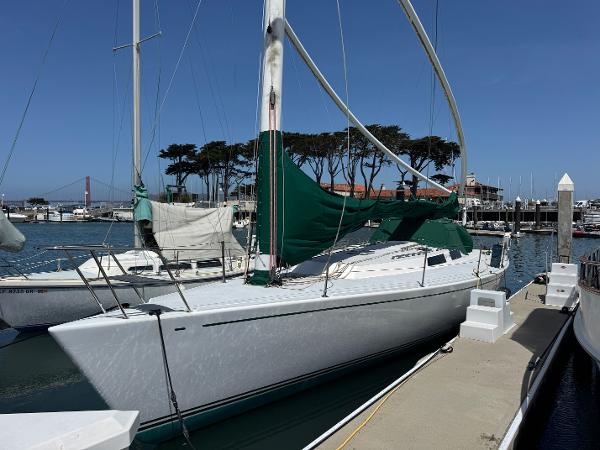 Sailboat Wyliecat 48, 2000 model, docked in a marina with clear blue skies.