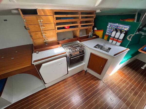 Interior of 2000 Wyliecat 48 sailboat with kitchen, stove, and wooden flooring.