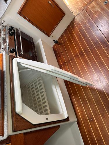 Interior of 2000 Wyliecat 48 showing open storage compartment and wooden flooring.