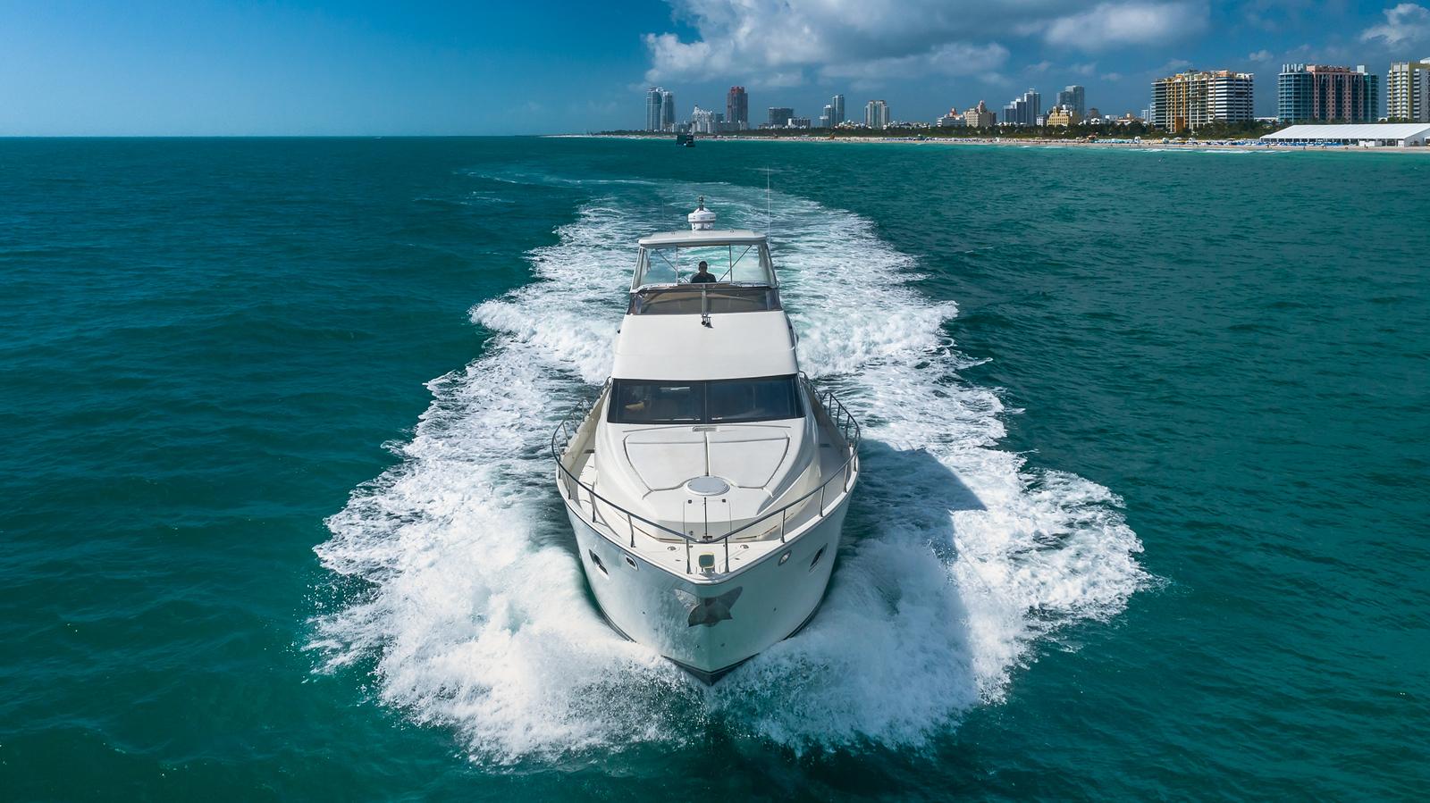 Marquis-59 2005-Next to Sell FL-US-Luxury 2005 Marquis 59 yacht cruising on turquoise ocean near city skyline.-9654462 | Thumbnail