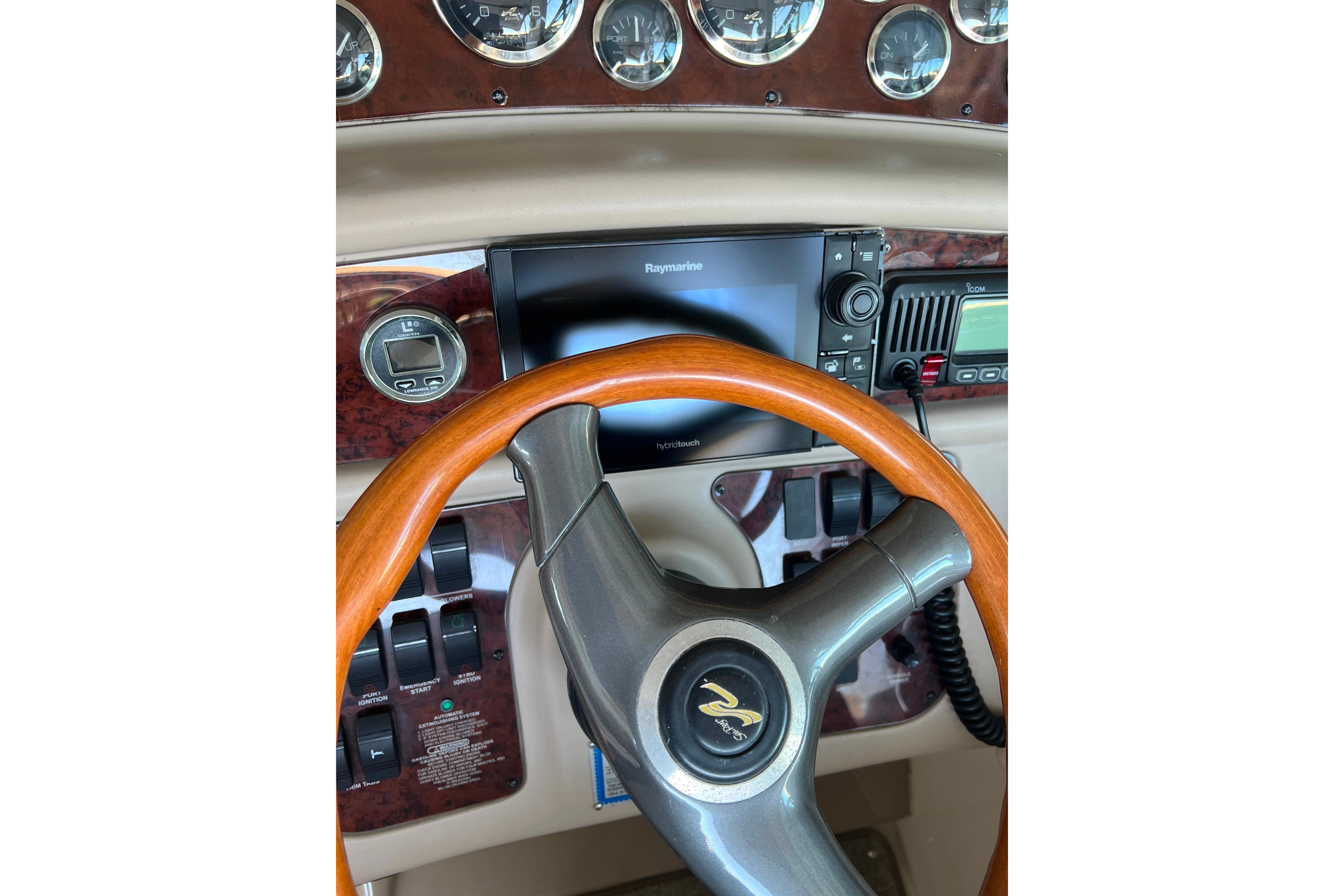 Steering wheel and dashboard of 1999 Sea Ray 290 Sundancer boat with navigation equipment.